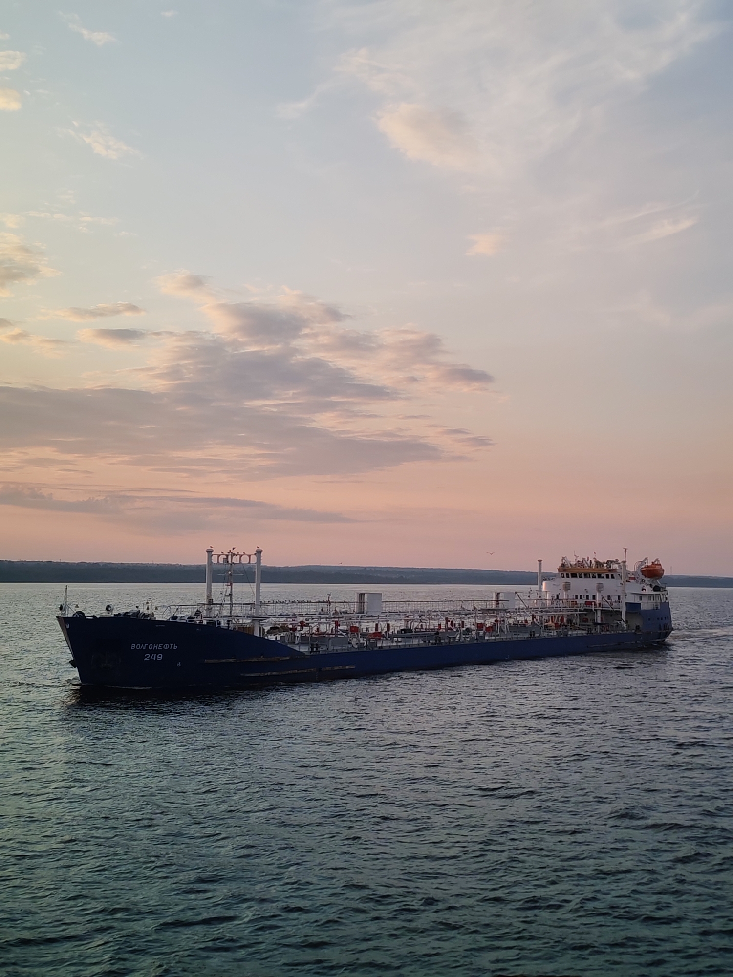 Sunset hours aboard a vessel, ships and big skies on open water