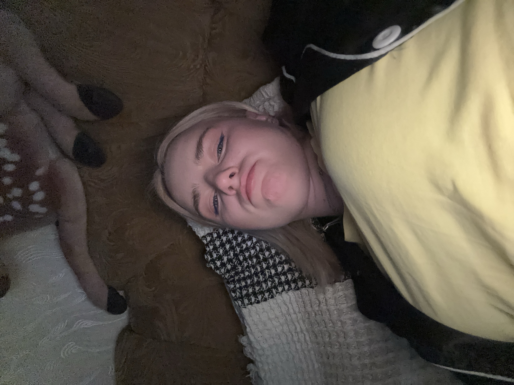 Casual couch selfies in a dim Russian room with a plush deer