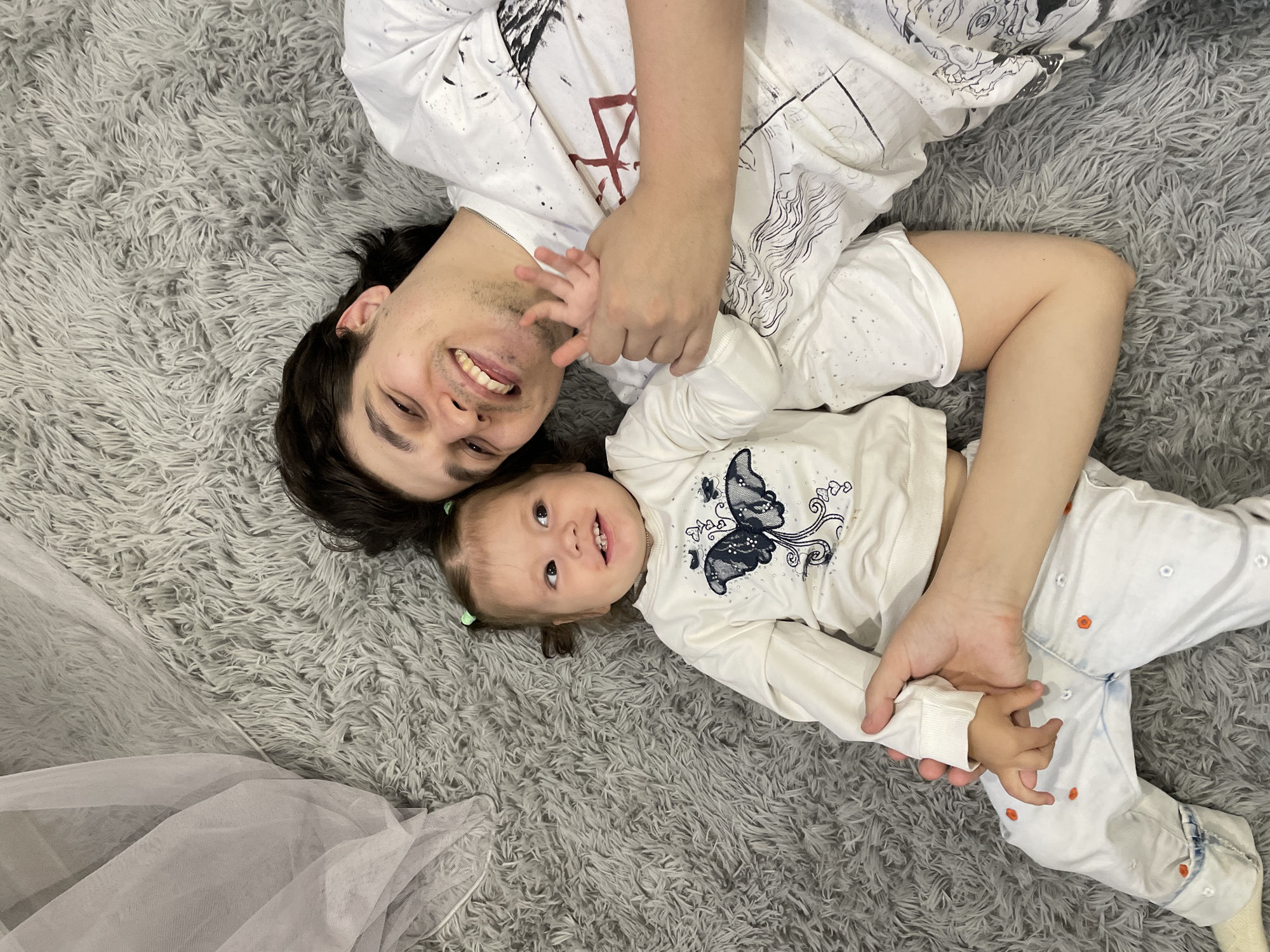 Father and child share quiet moment on rug in Izhevsk