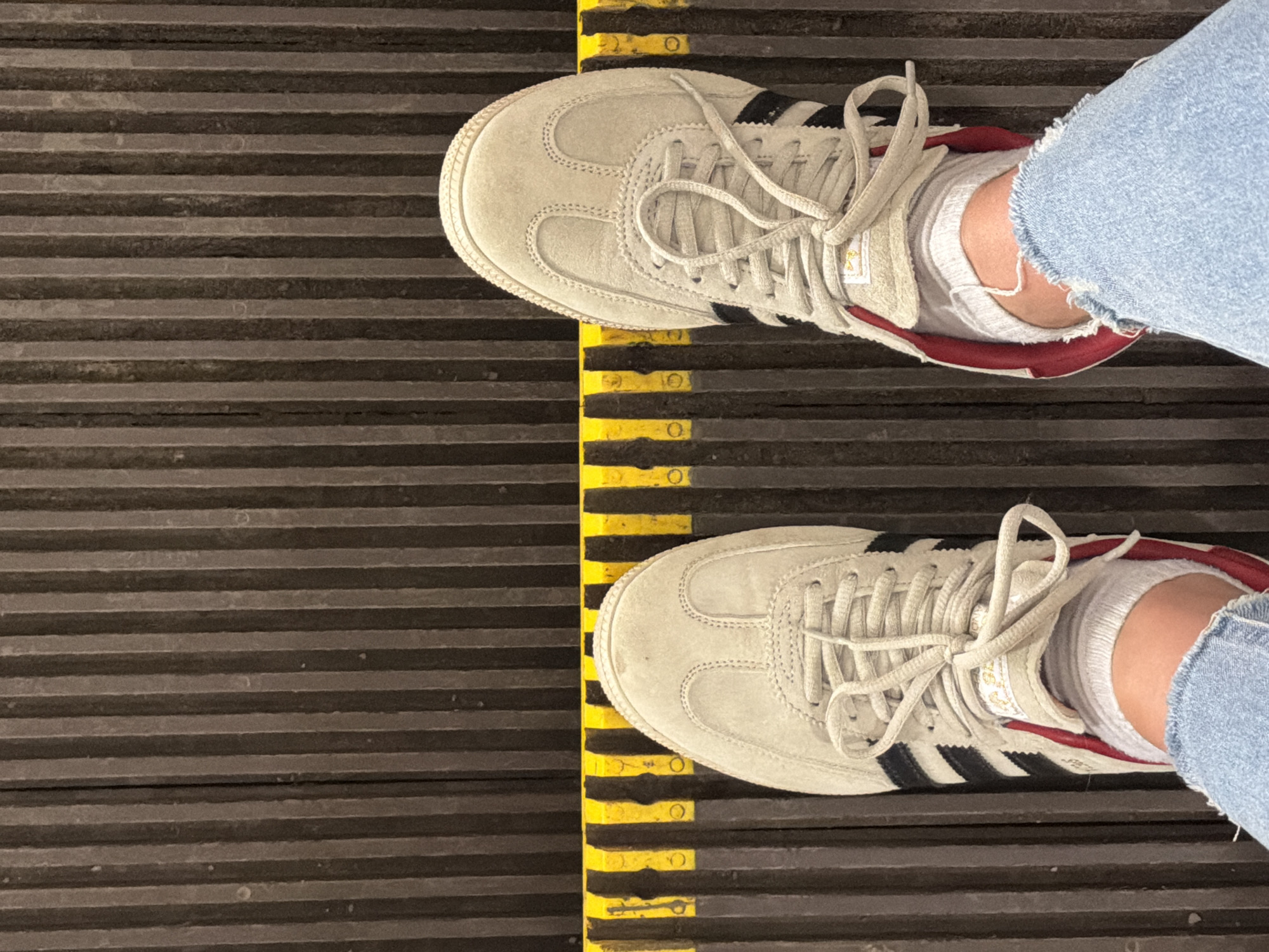 Person in Adidas sneakers rides Moscow escalator early morning