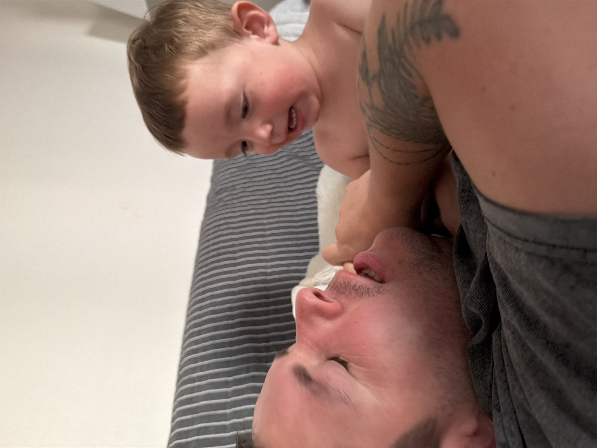 Playful couch moment between adult and child at home