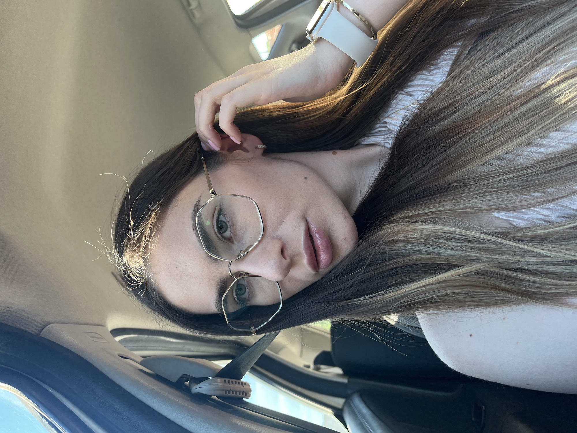 Woman with glasses observed in car driver's seat