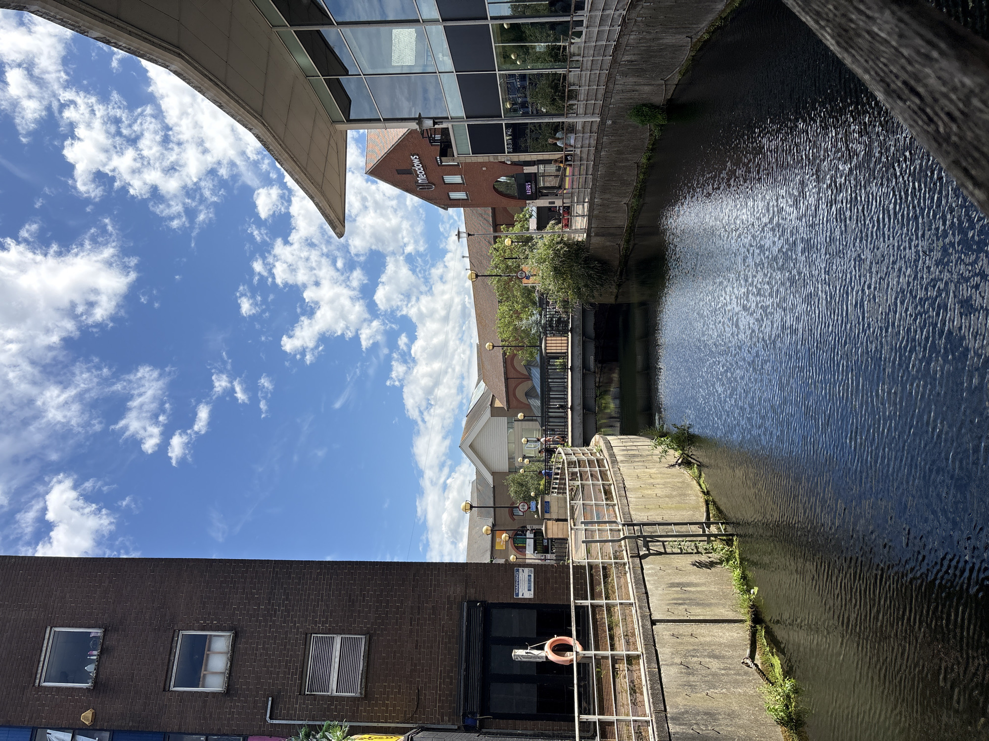 Canal walk through urban greenery with wildlife and street details