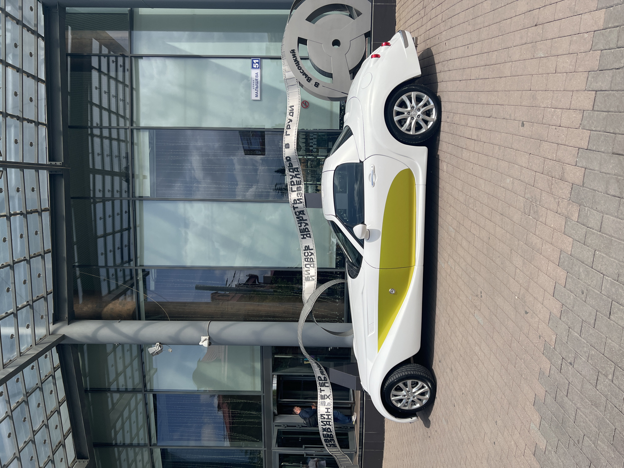 White convertible parked near modern building in Yekaterinburg