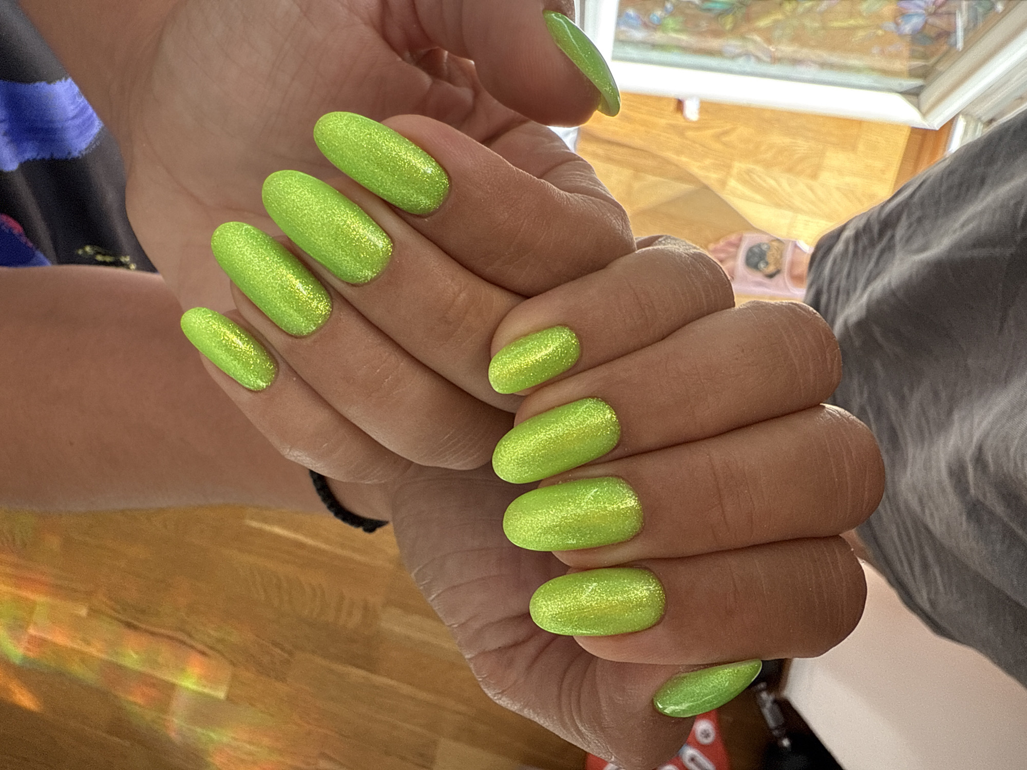 Person shows off bright green glittery manicure in photos