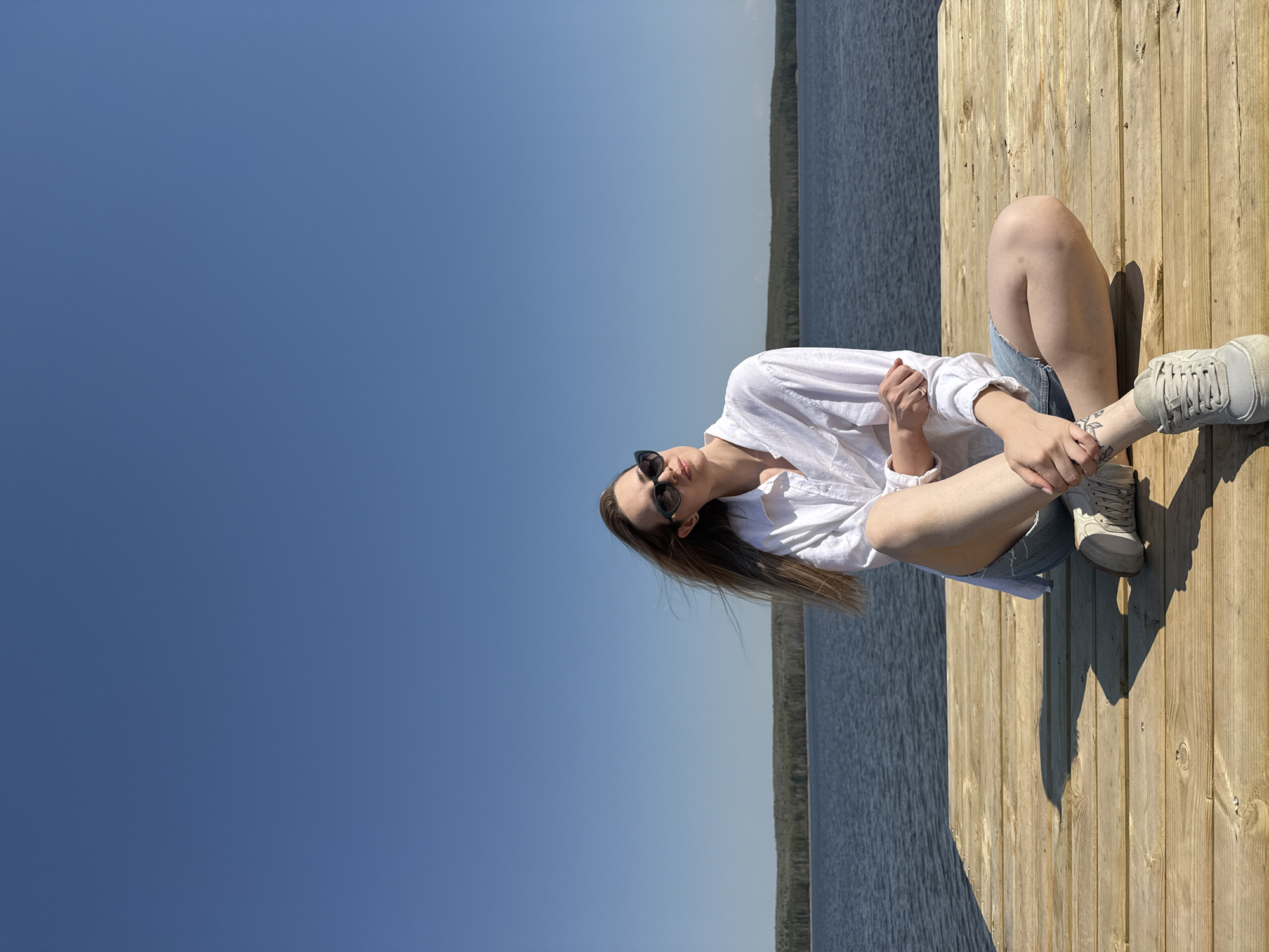 Woman enjoys morning moments on wooden pier in Chaikovsky