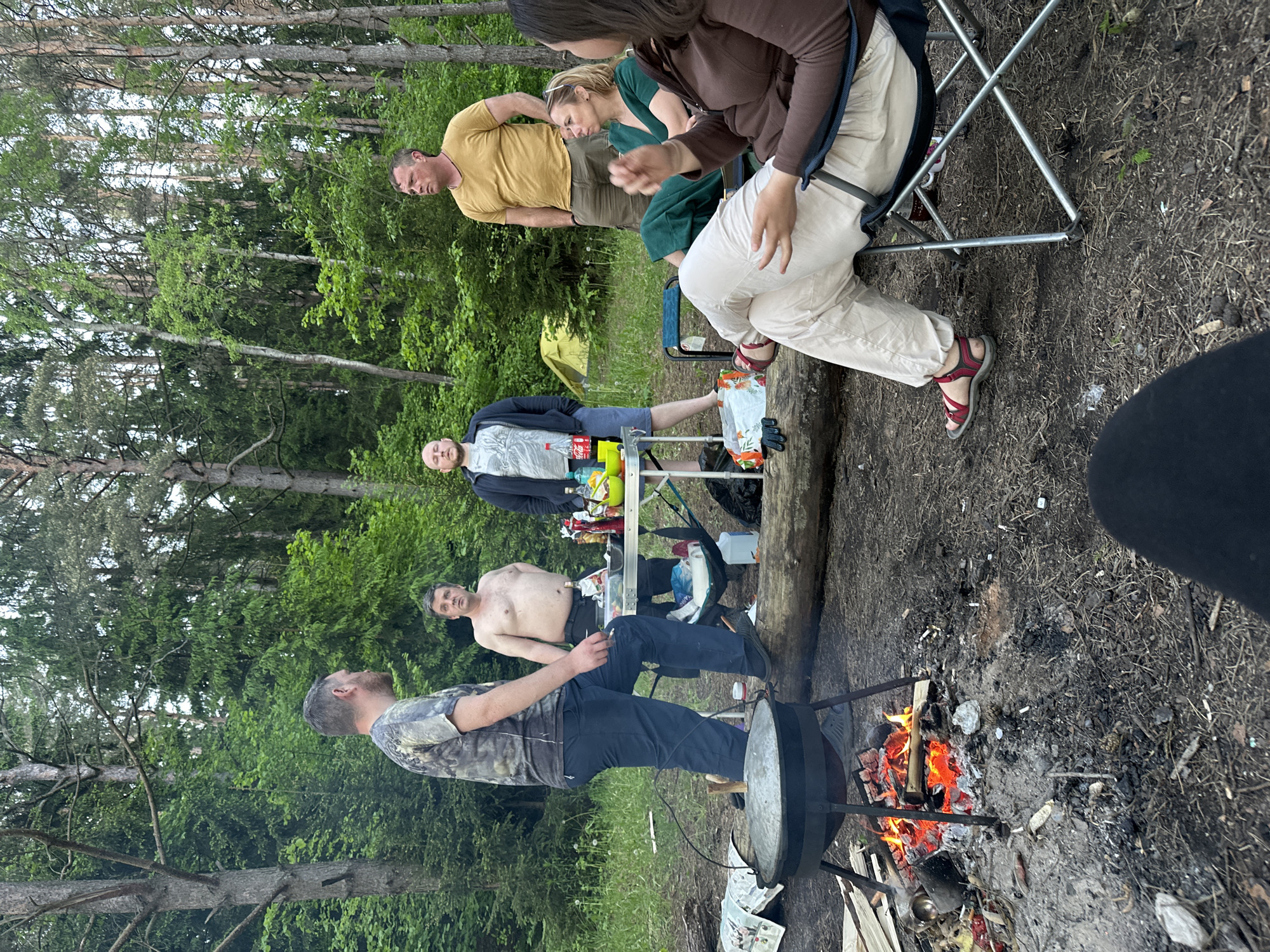 Camping group cooks outdoors in Belarus forest