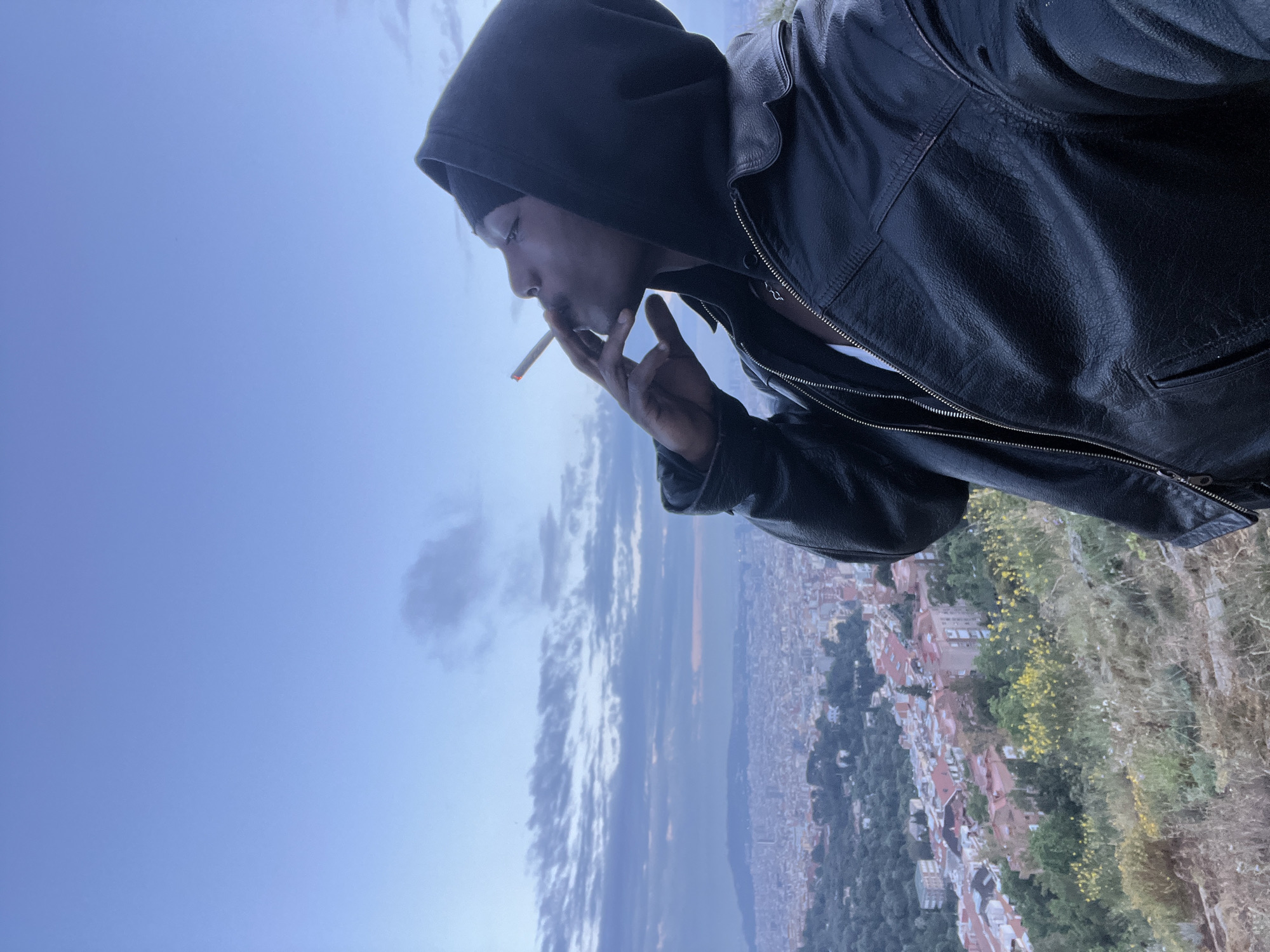 Man smoking on Barcelona hillside overlook captured from multiple angles