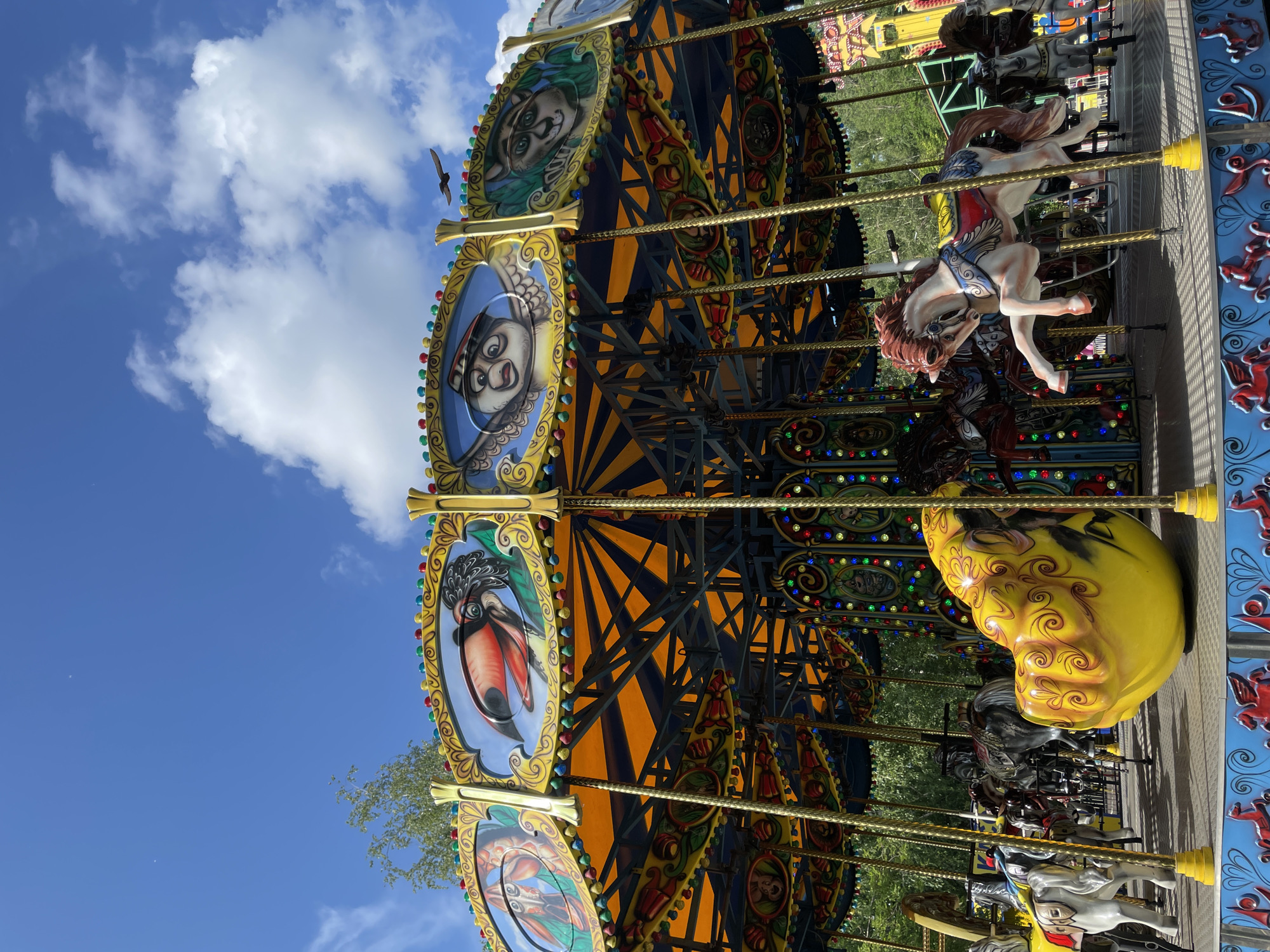 Ornate carousel spins on a sunny day in Novokuznetsk