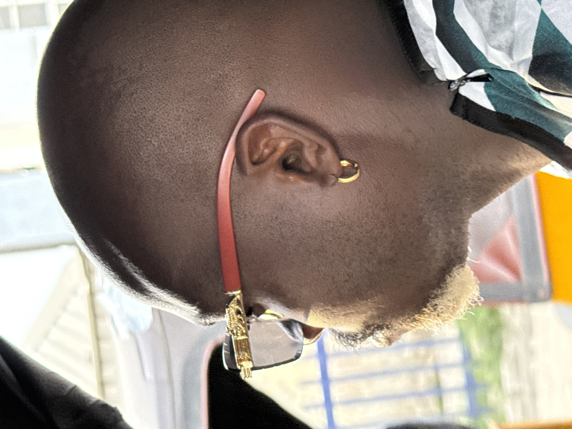Man with gold earrings, red sunglasses photographed in Ikorodu