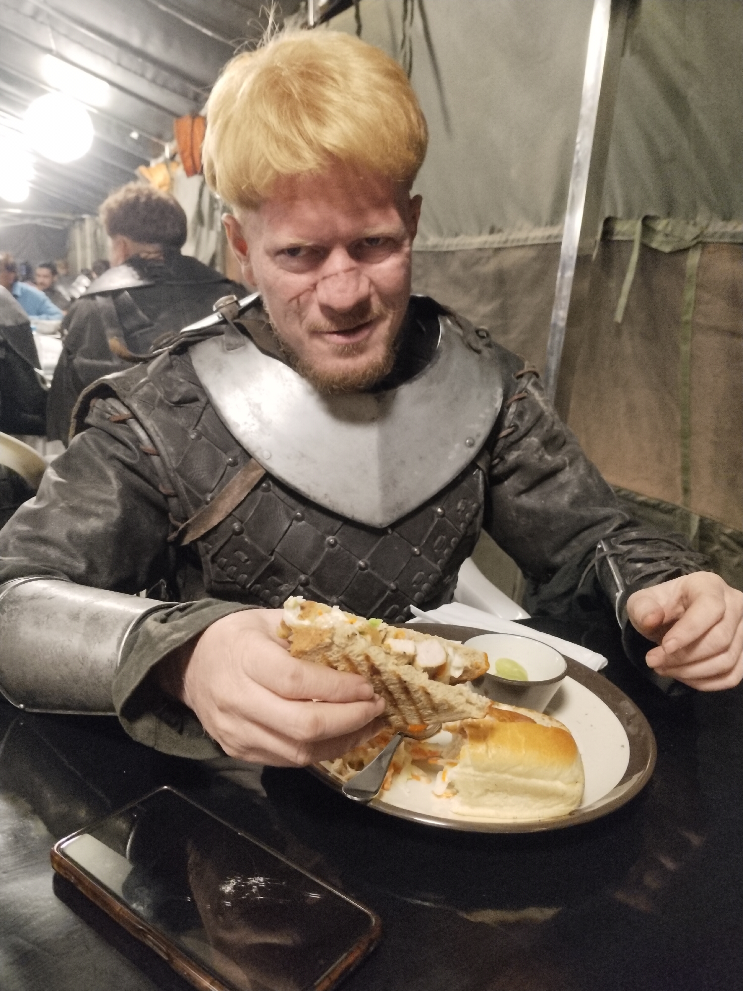 Costumed figure dines at tent food service in Mumbai