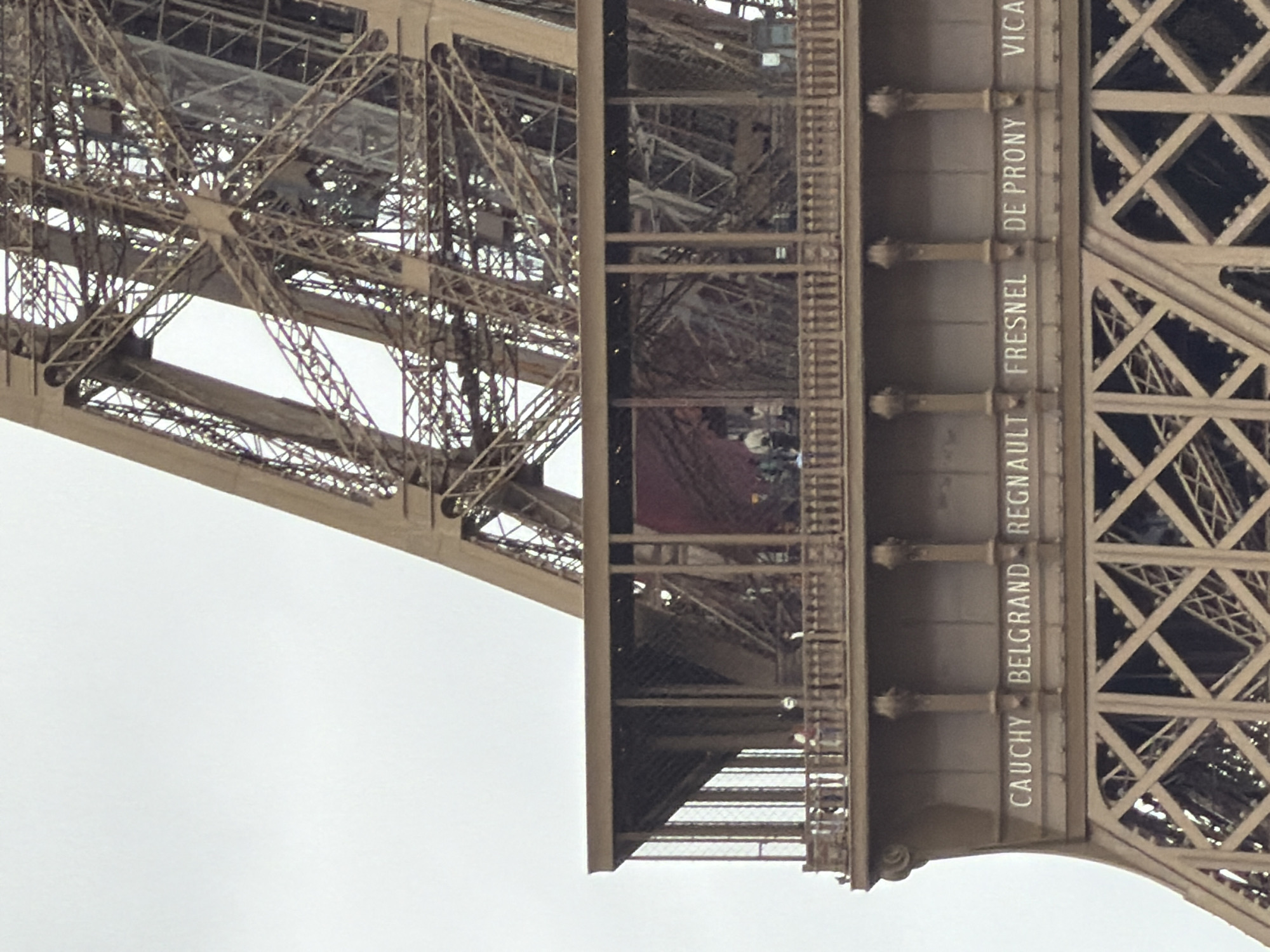 Tourist documents Eiffel Tower visit during overcast Paris afternoon