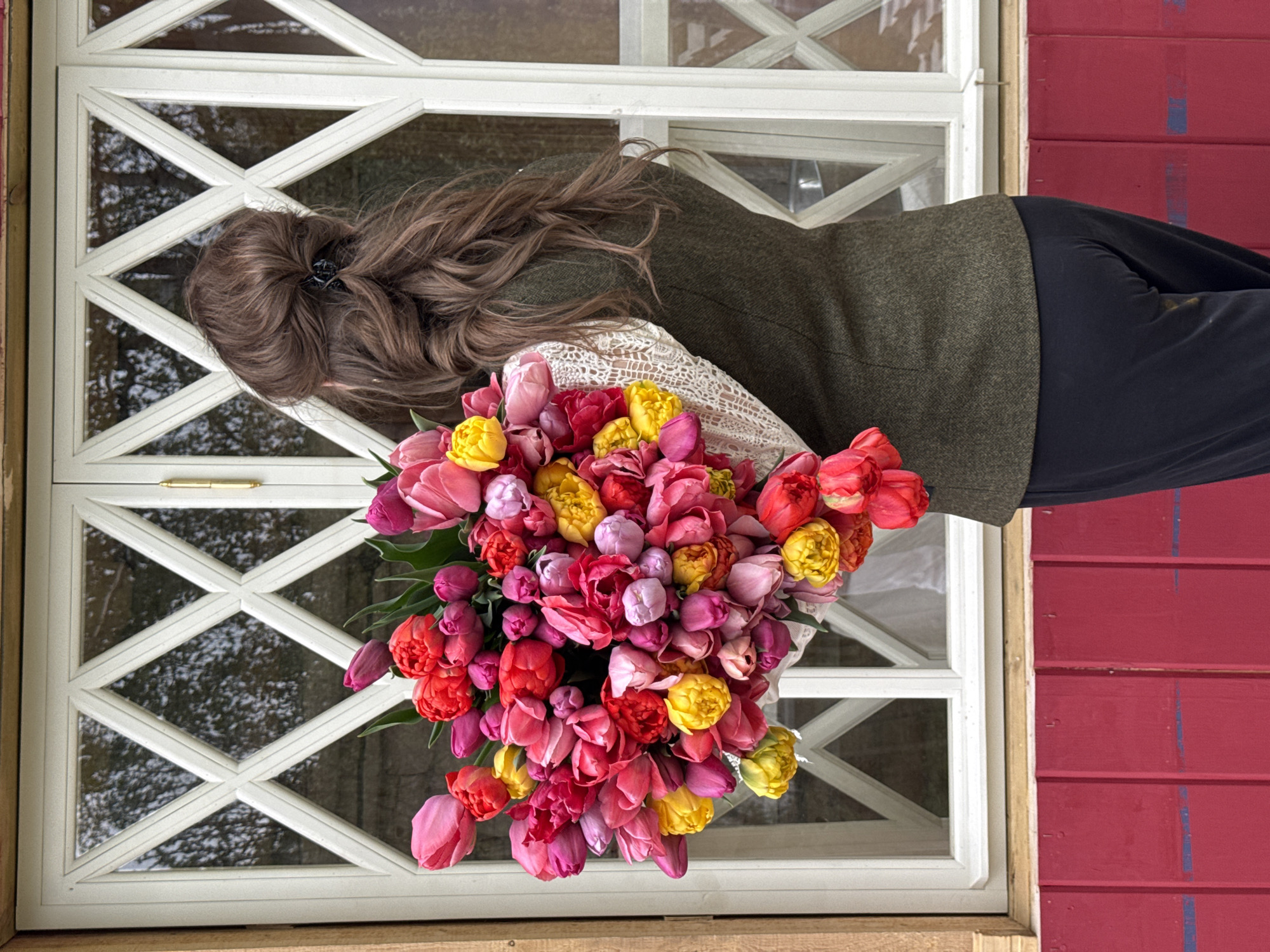 Woman holds colorful tulip bouquet in Sapronovo, Russia