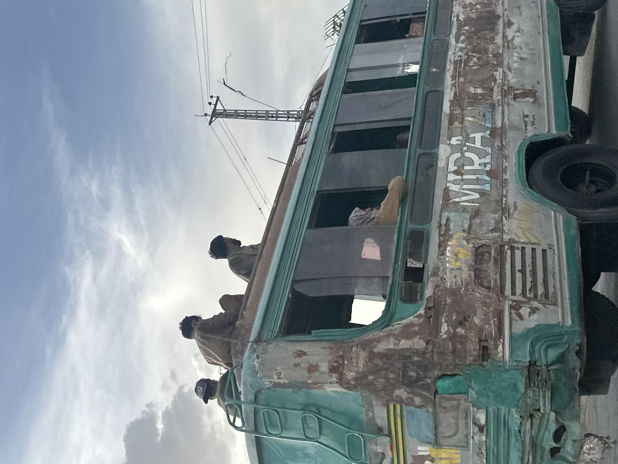 Men ride atop dilapidated bus in Quetta, Pakistan