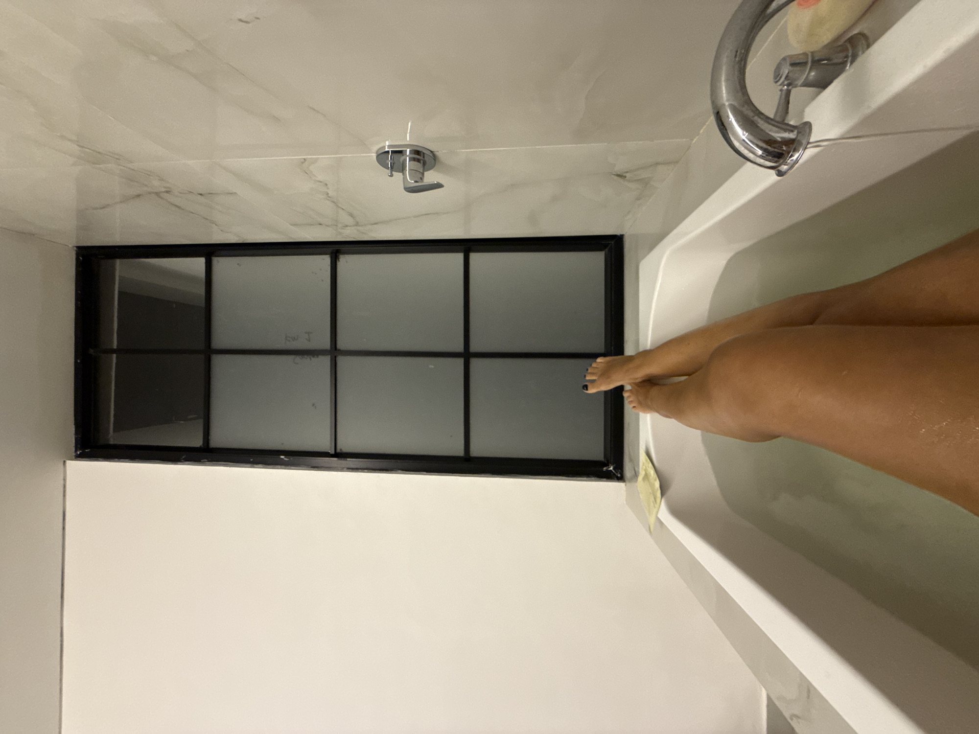 Person bathing in tiled bathroom in North Kuta