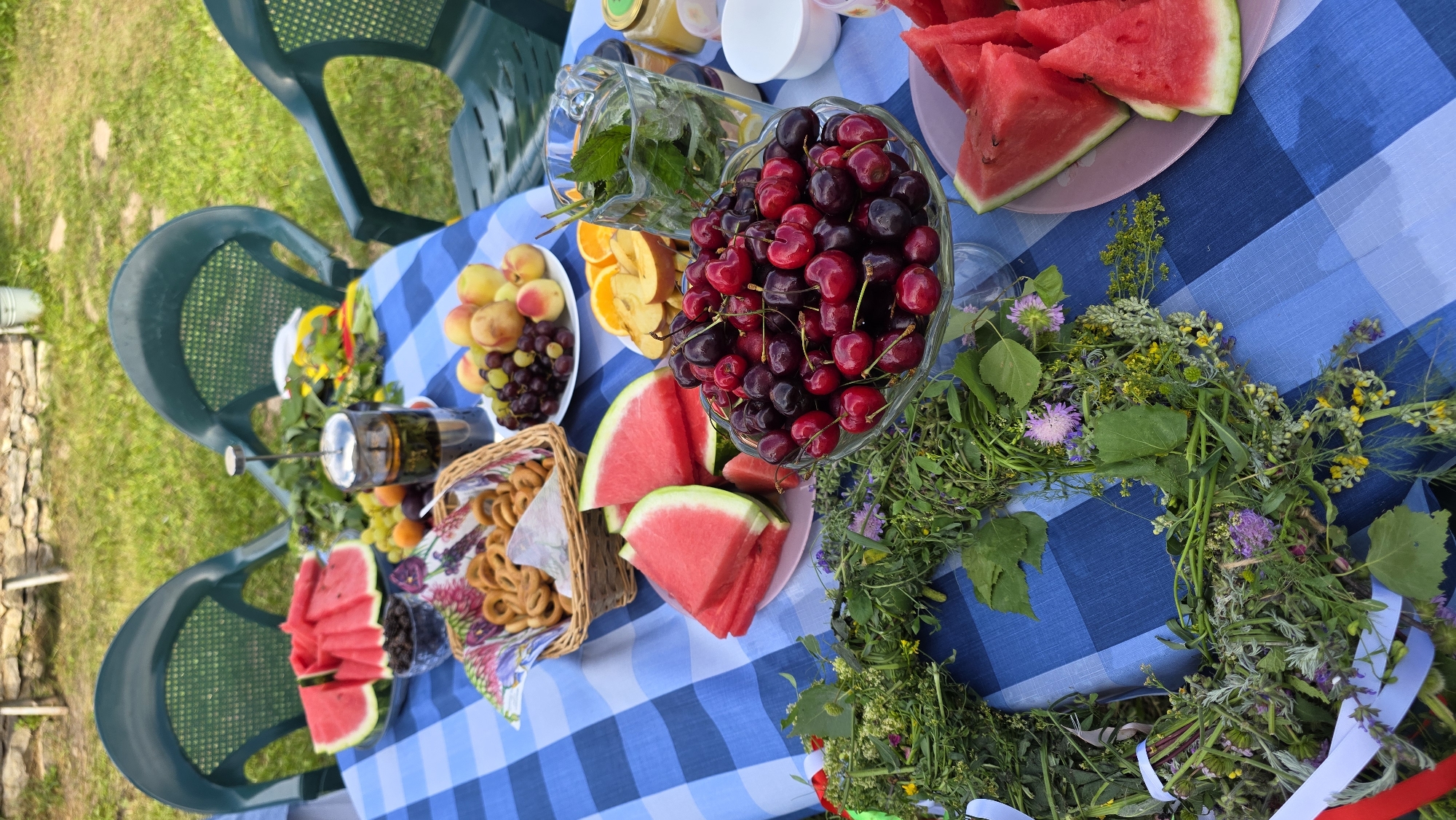 Summer picnic spread with food and wildflower arrangements in rural Russia