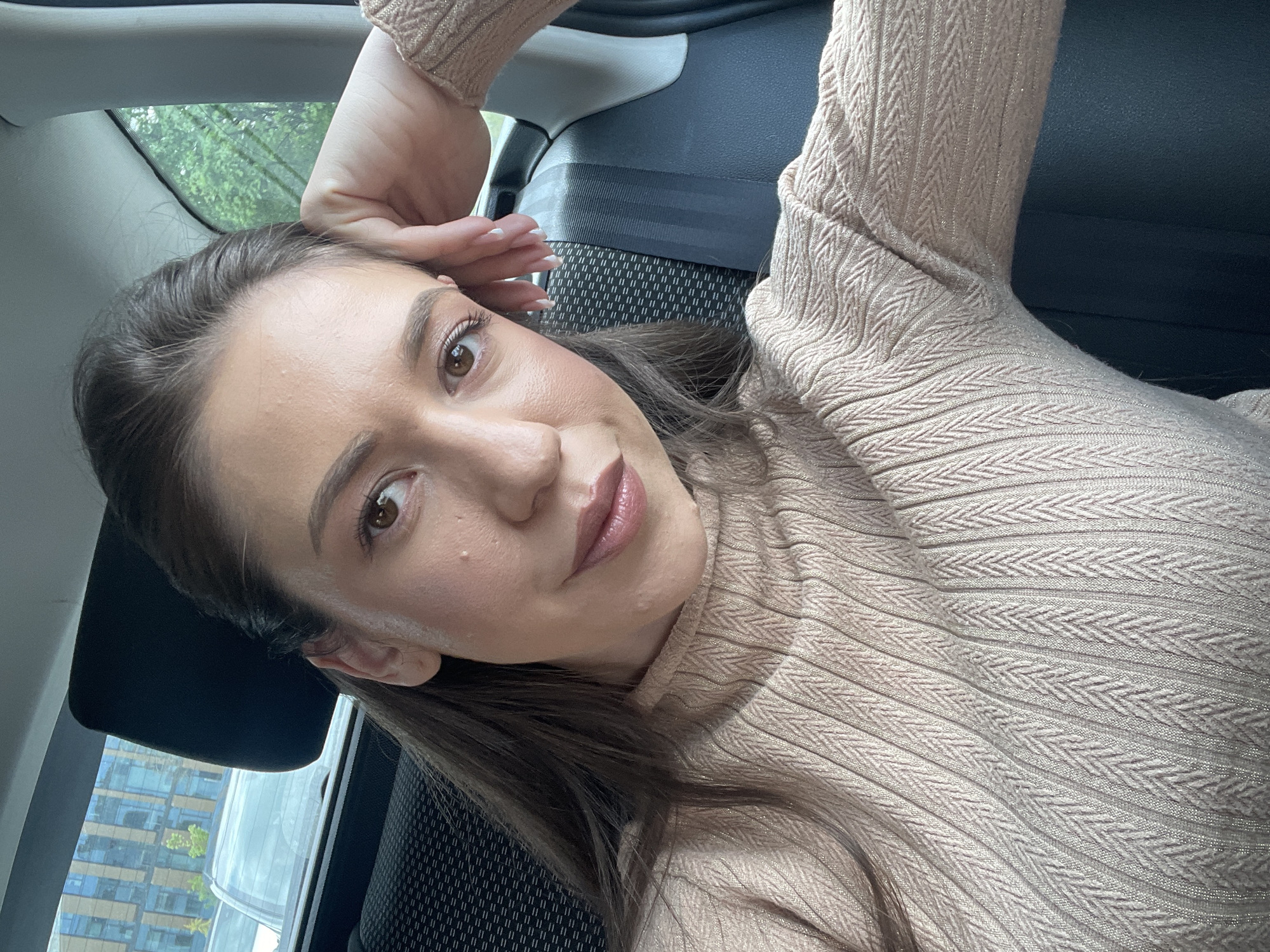 Woman in beige sweater observed resting in car, Sofia