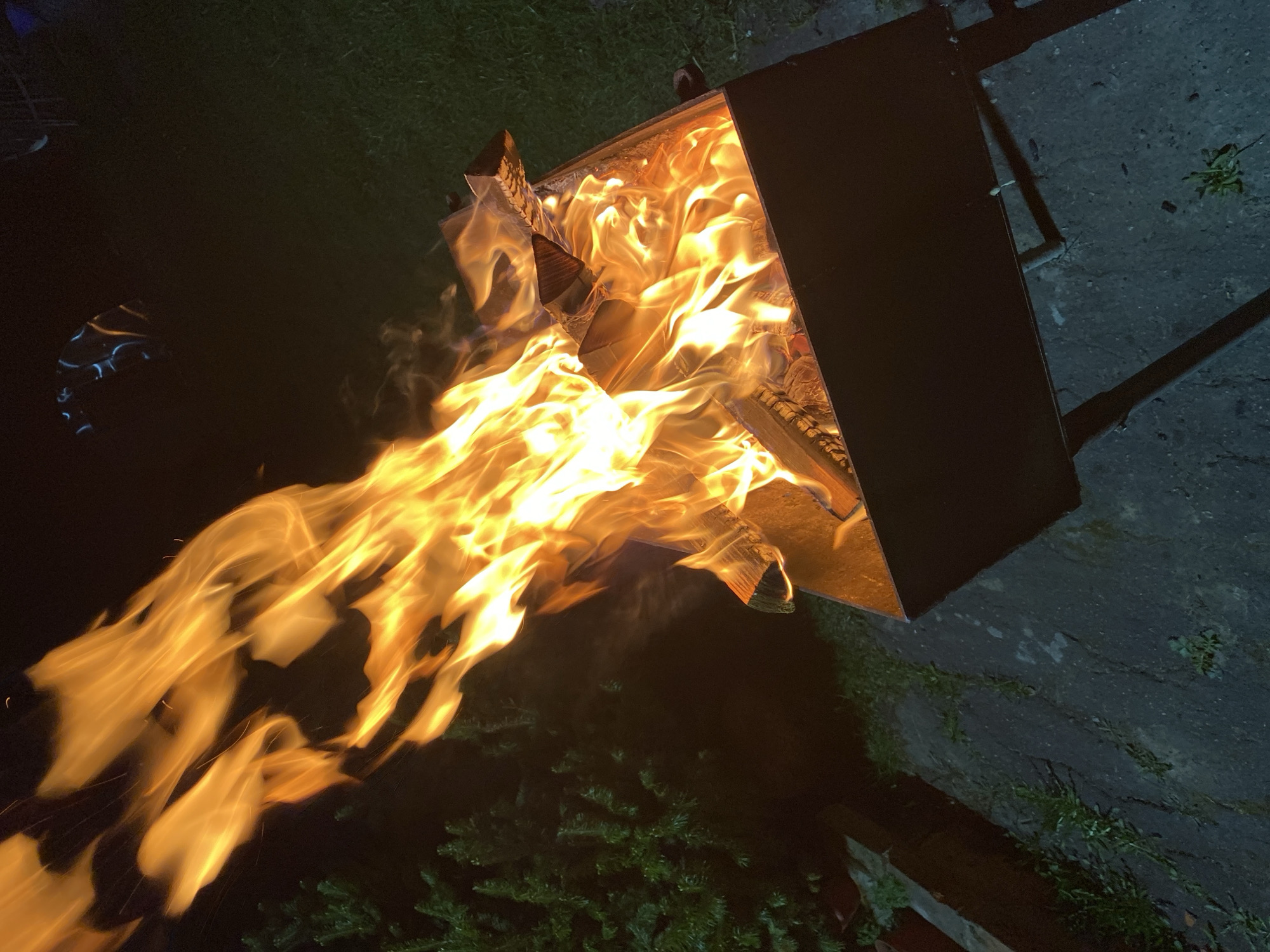 Fire pit burns as woman enjoys waffle cookie in Красный Маяк