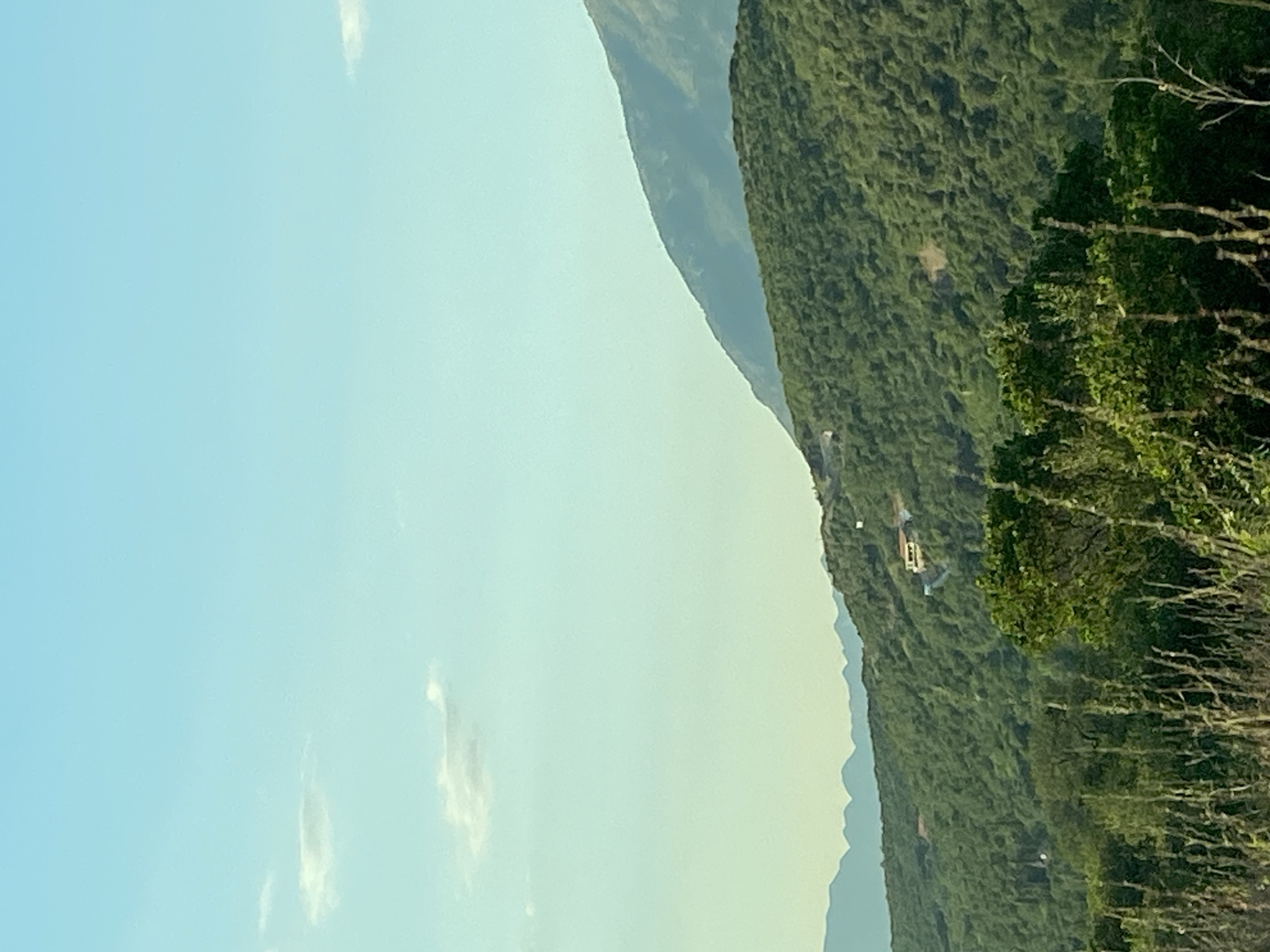Plane crosses clear skies above Montenegro's green hills