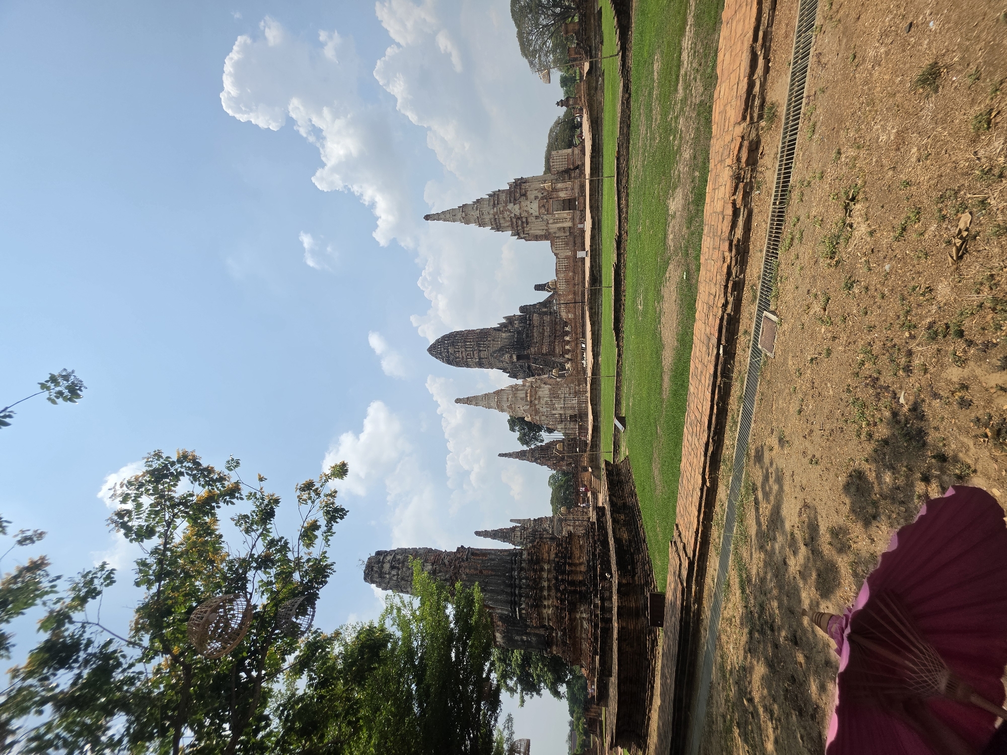 Tourist documents ancient Thai temple ruins during morning visit