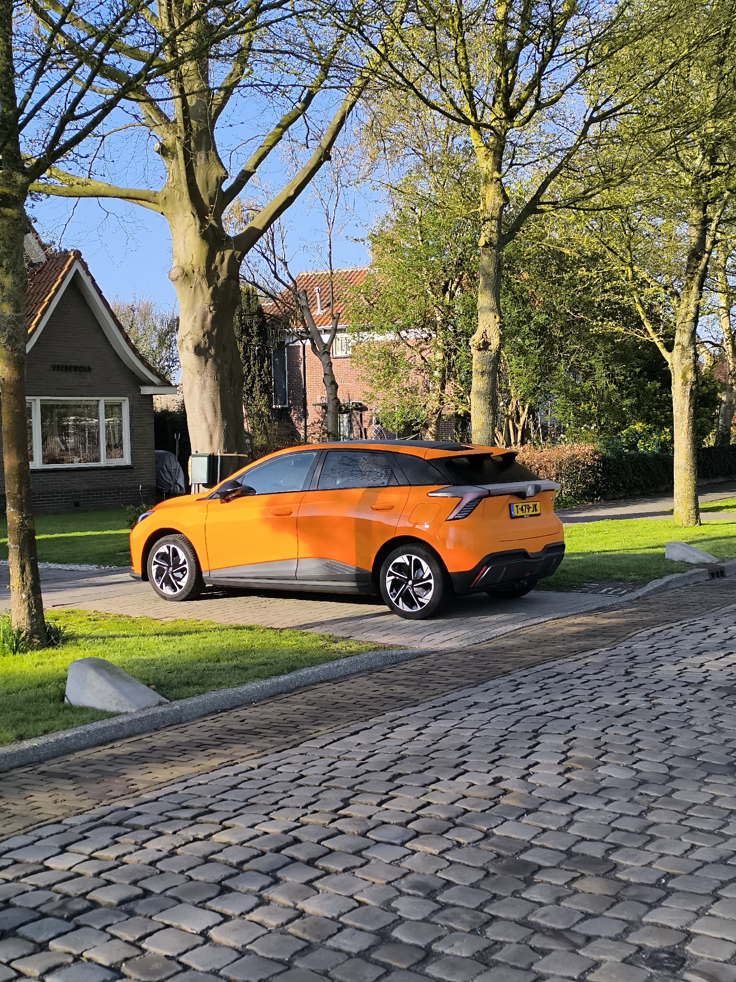 Orange electric car parked in Alkmaar residential driveway