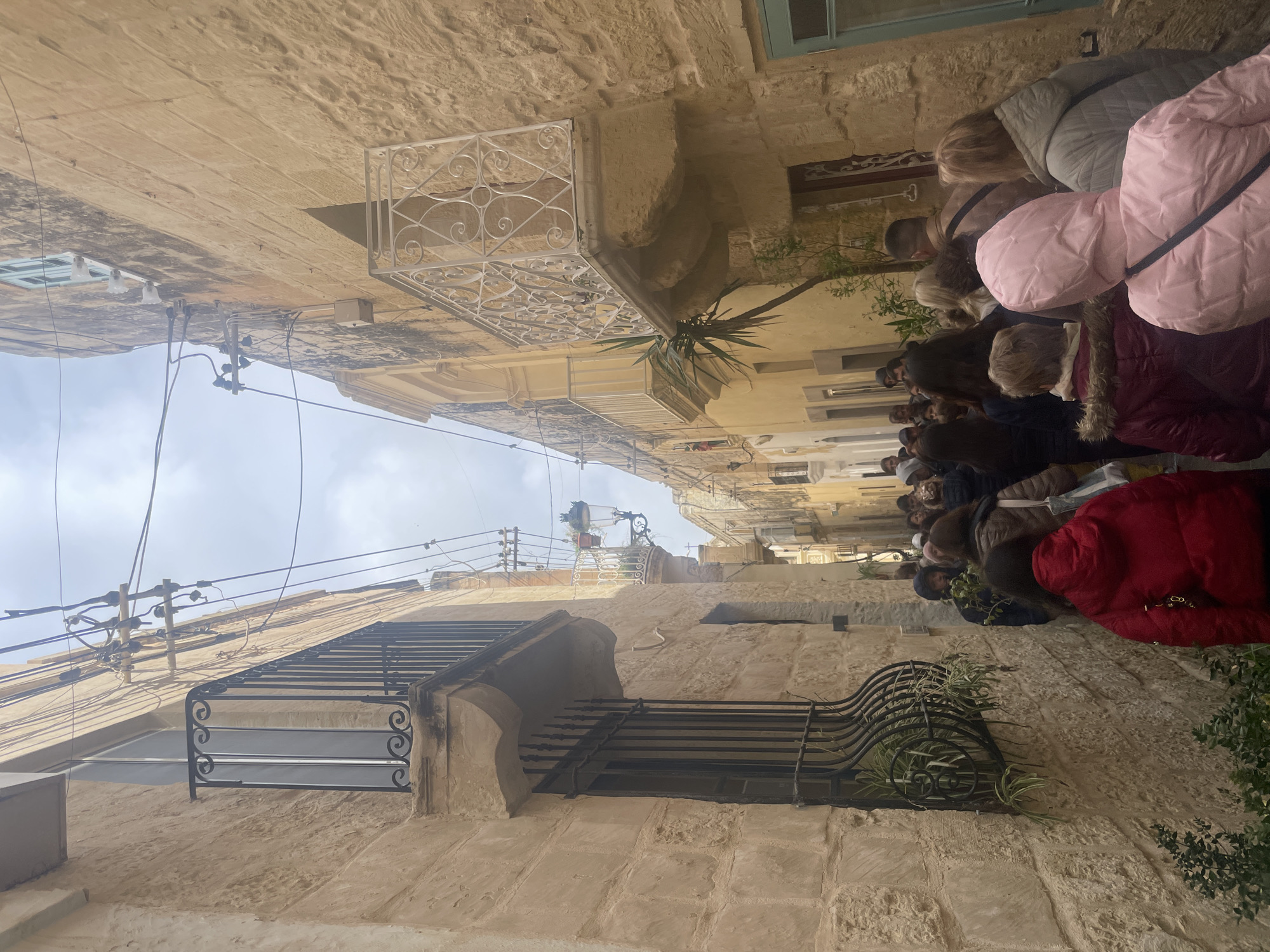 People gather on historic street in Rabat, Malta