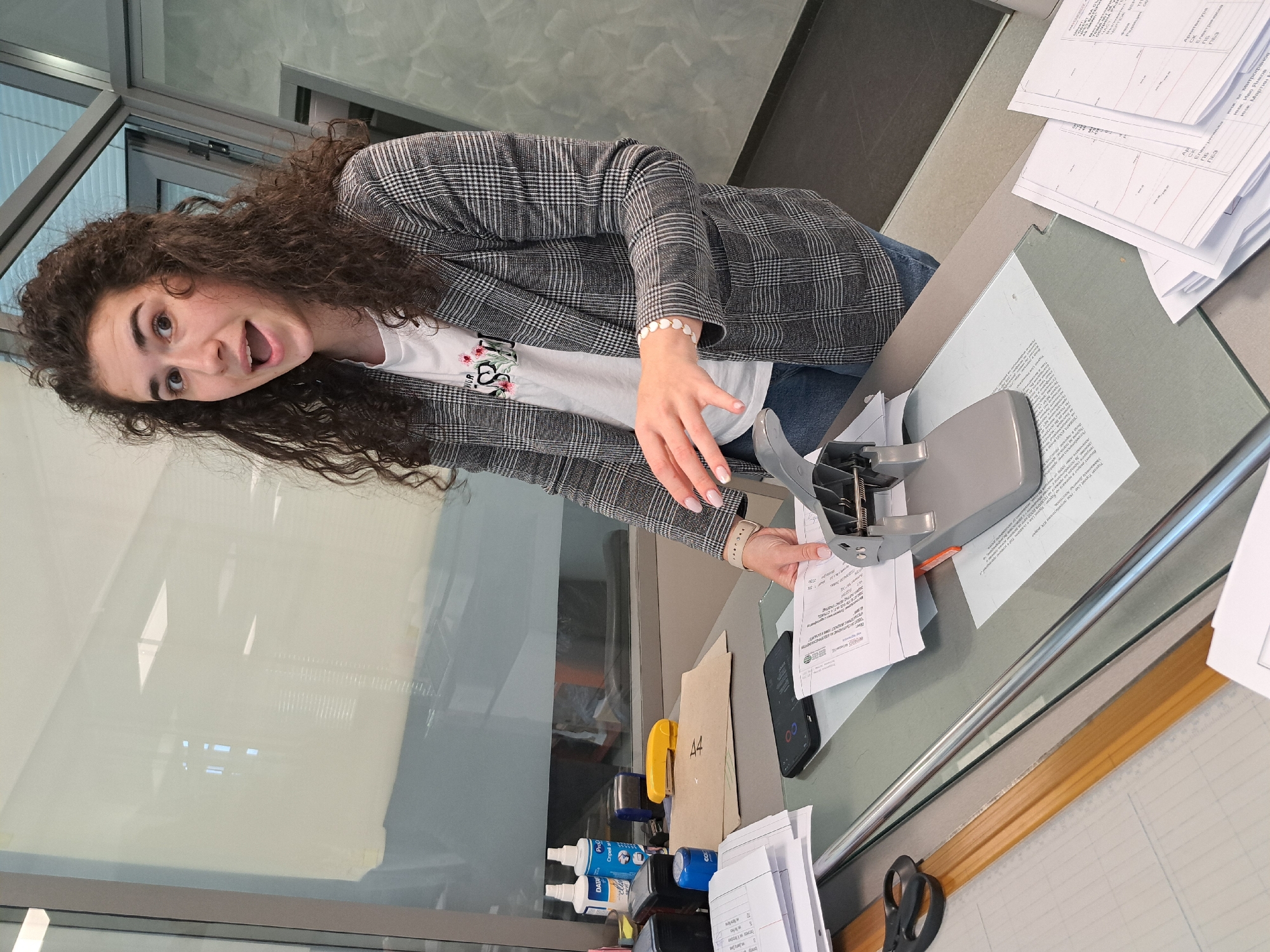 Woman operates paper punch in office setting