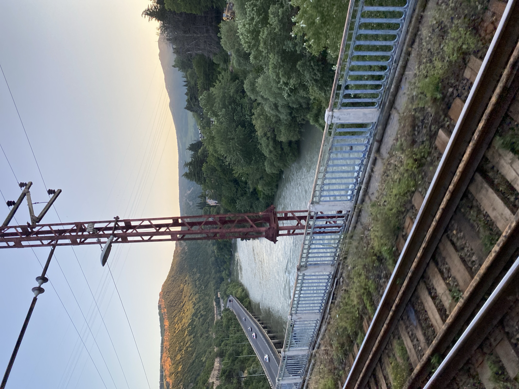 Bridge view over Tbilisi's river valley, green hills all around