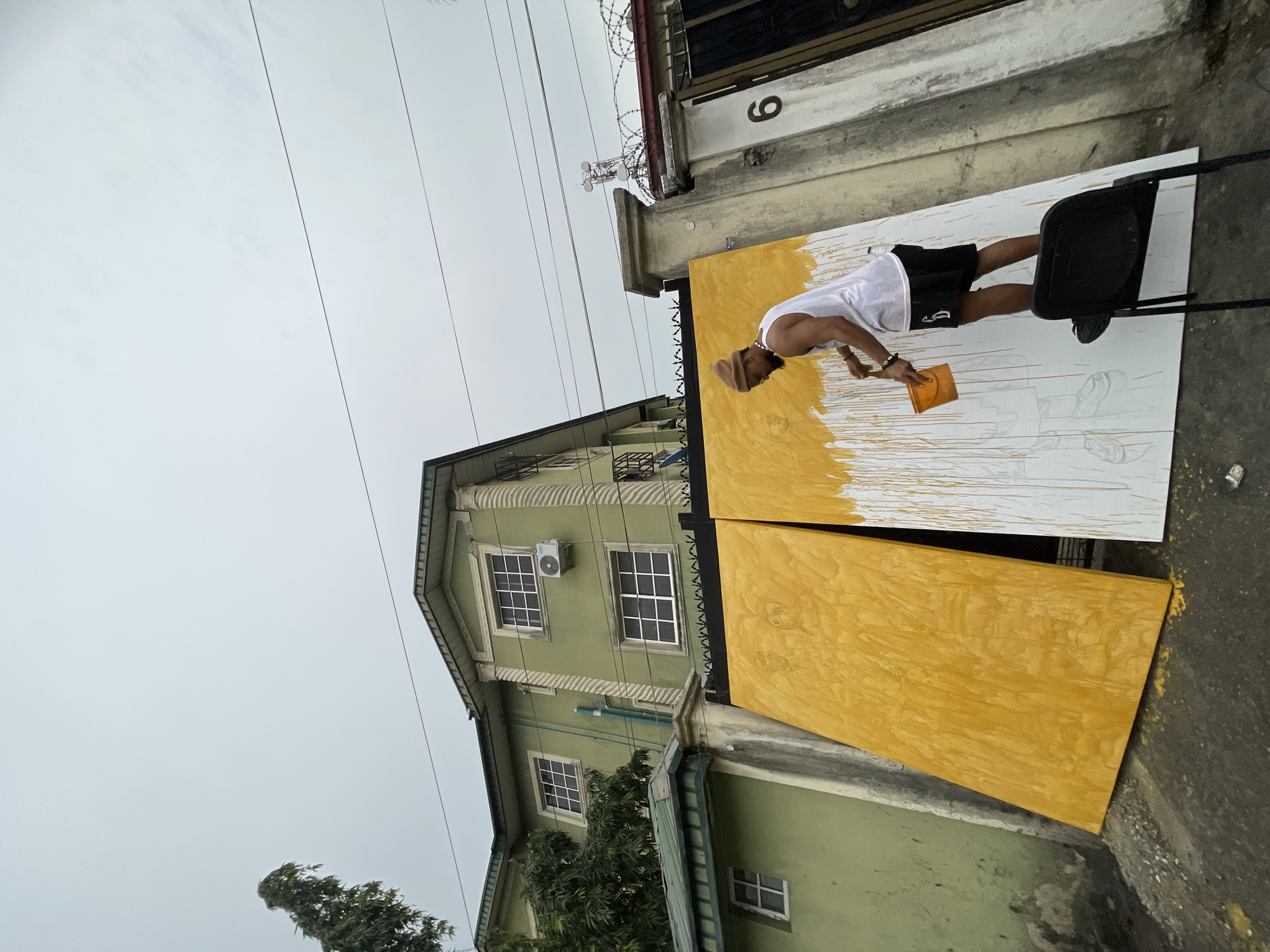 Street artist paints figure portraits outdoors in Ado, Nigeria