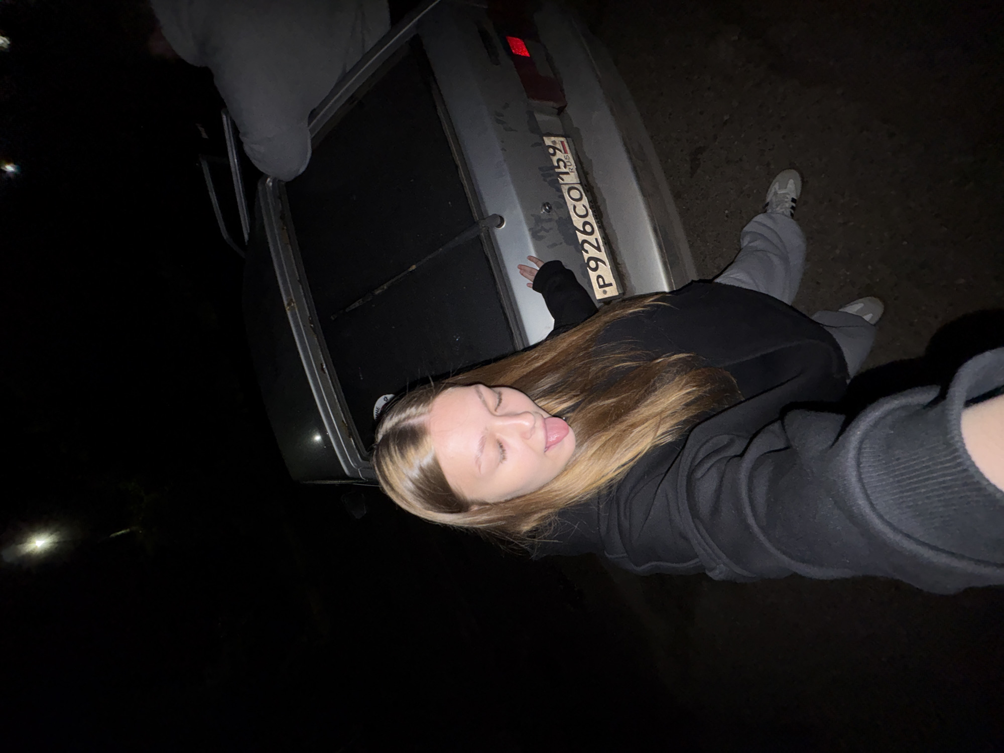 Young couple photographed with car during nighttime encounter in Chaikovsky