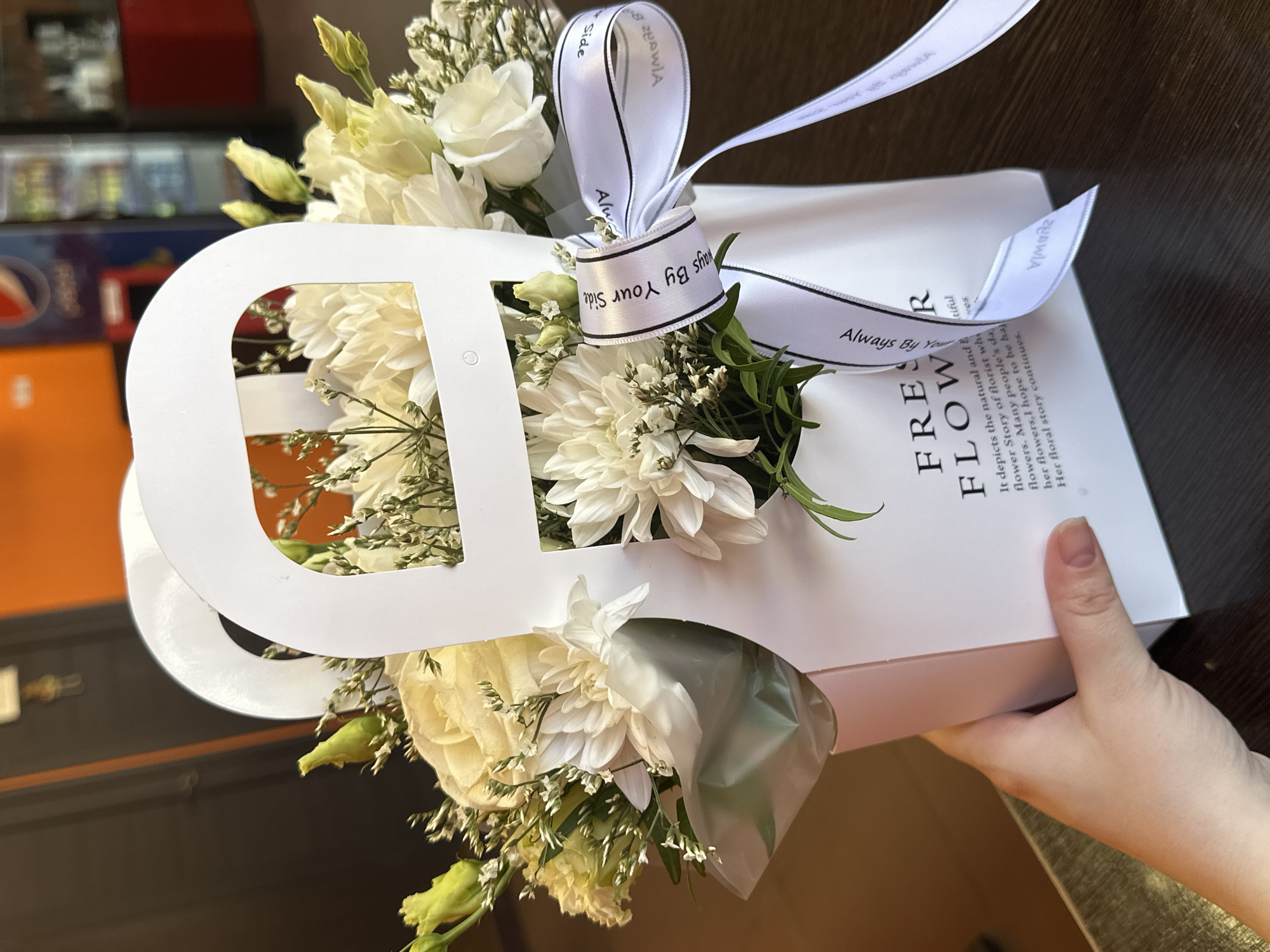 White flower arrangement documented with ribbon and pink ice cream