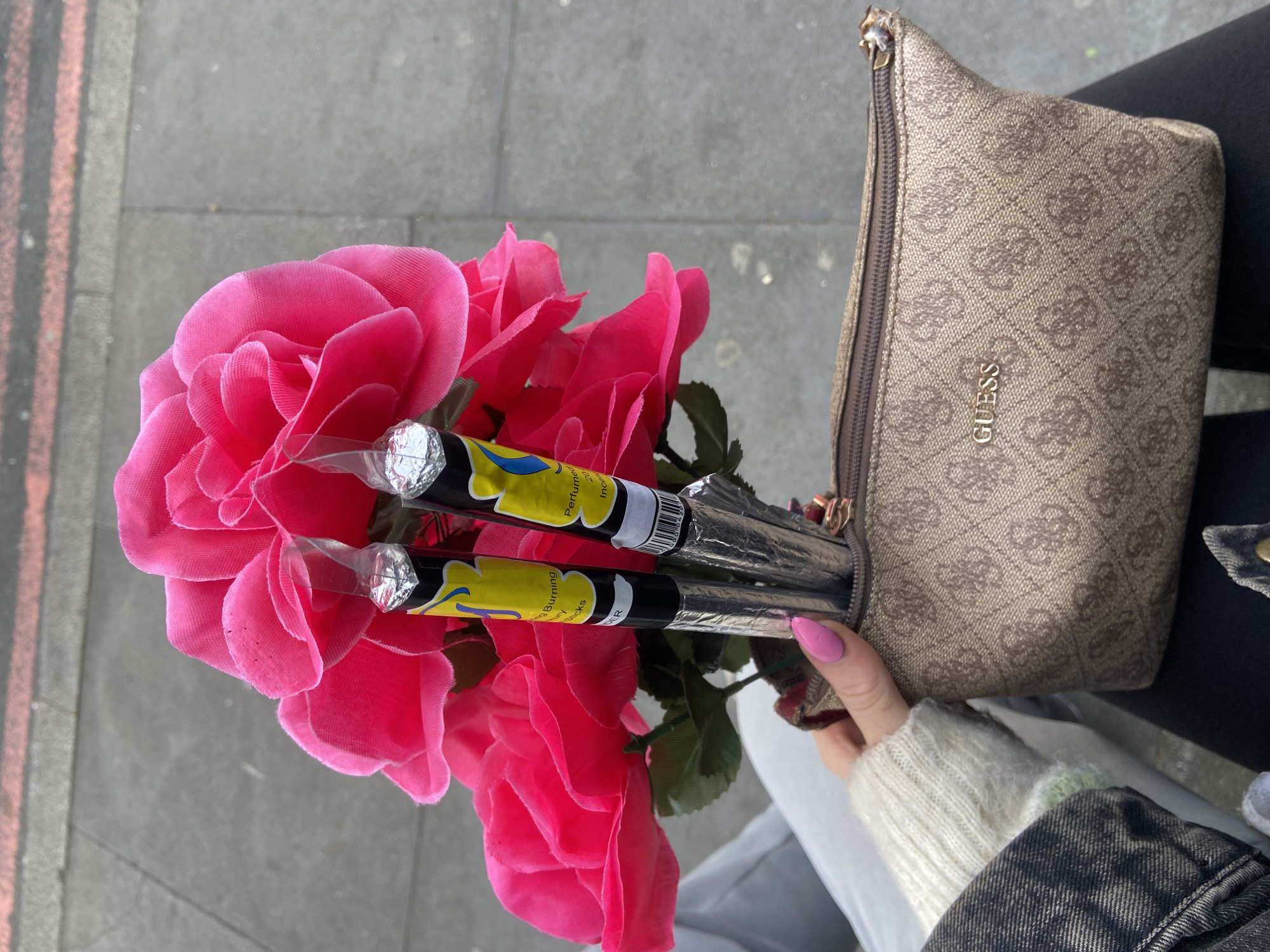 Person holds artificial roses and incense in London