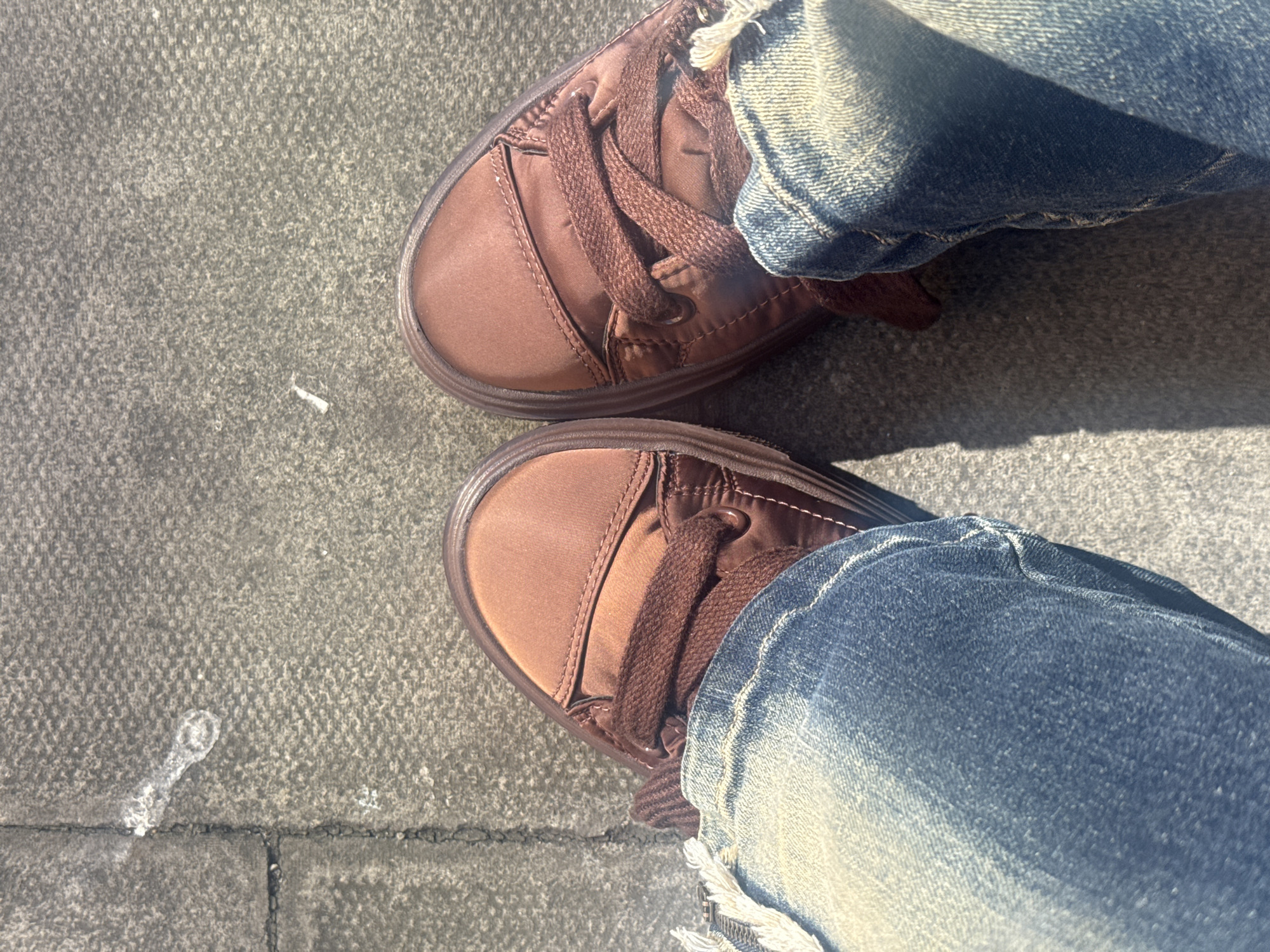 Person in casual shoes stands on London sidewalk