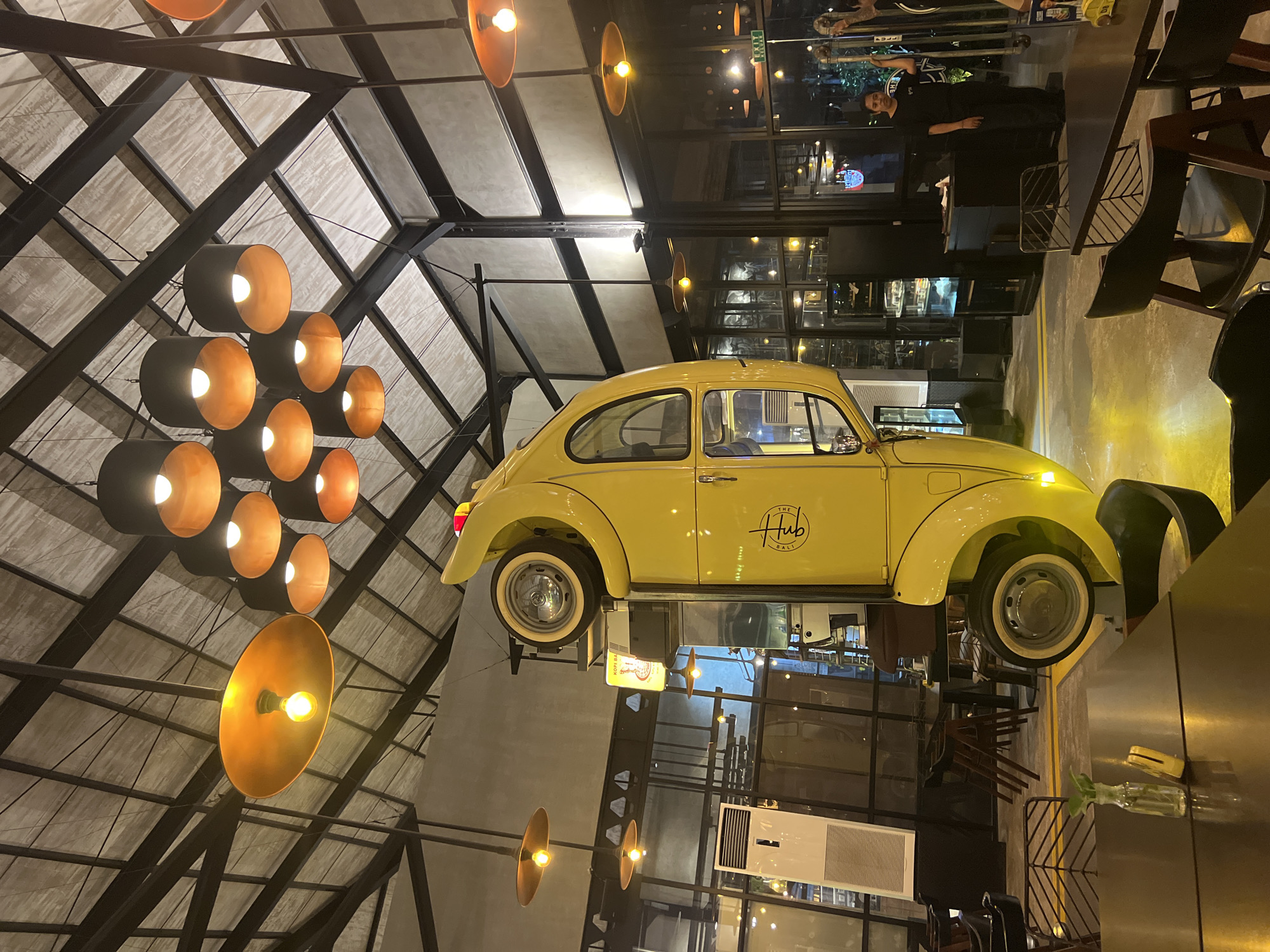 Upside-down yellow Beetle art installation draws visitors at Denpasar restaurant
