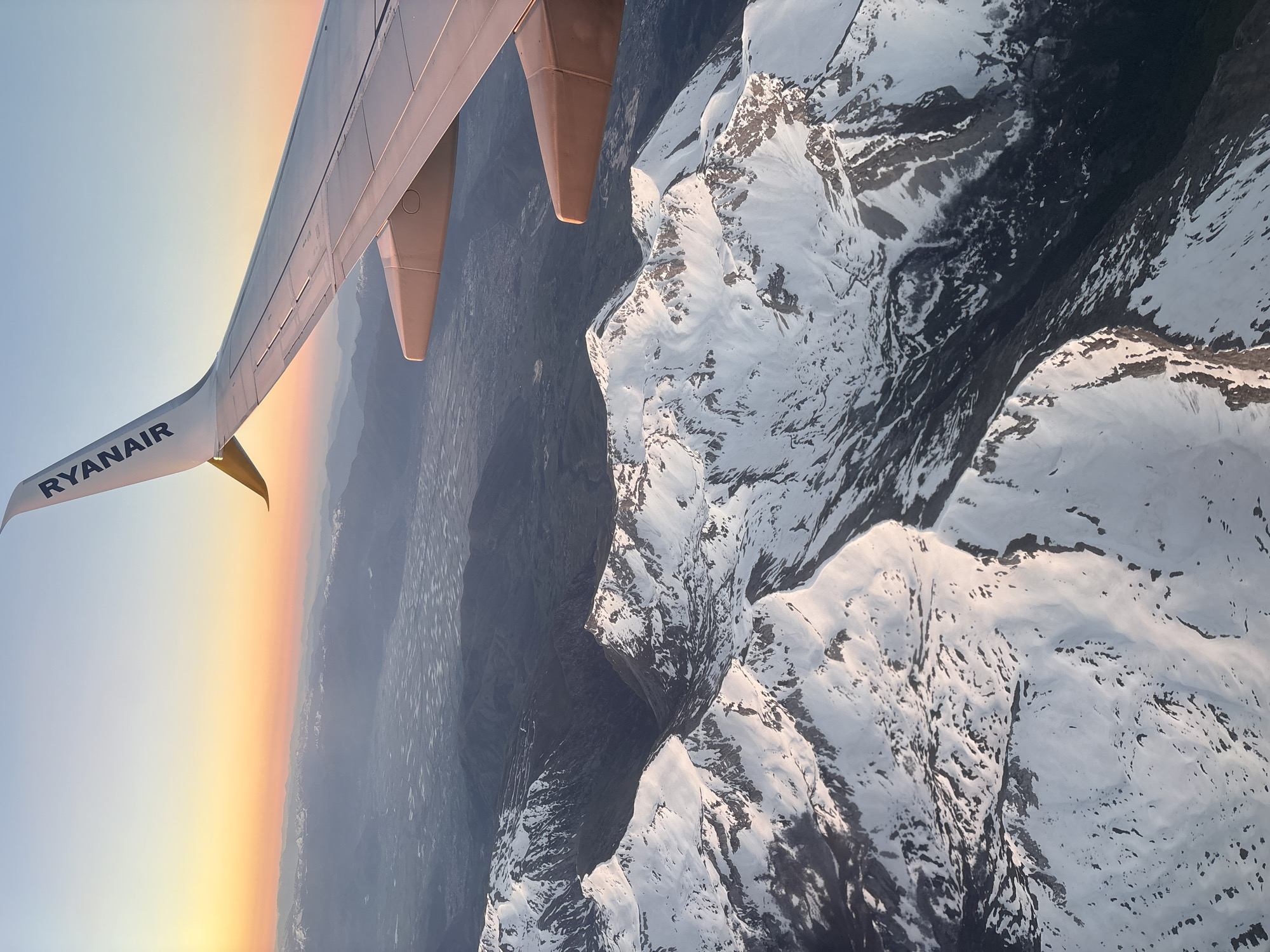 Aerial photo captured from airplane over Rome showing wing, mountains