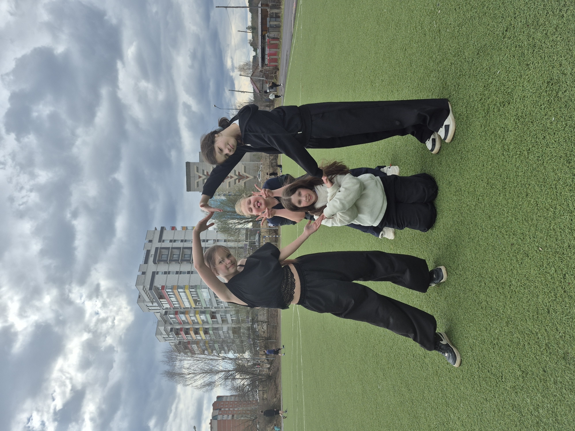 Young women pose playfully on sports field in Chaikovsky