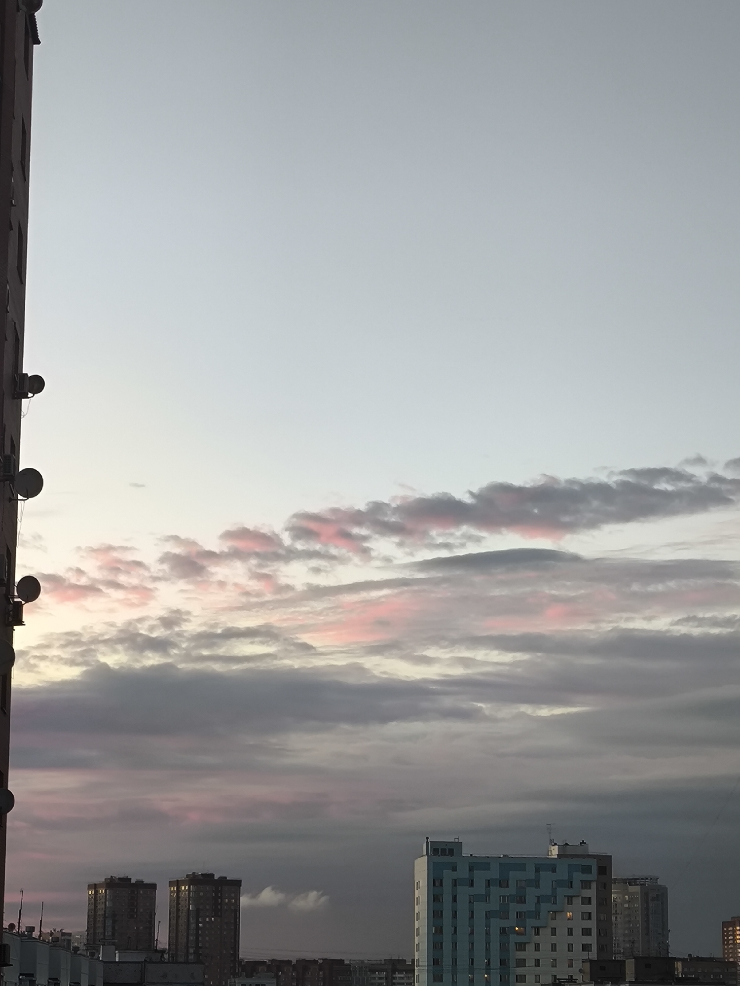 City skyline at dusk with pink-tinged clouds