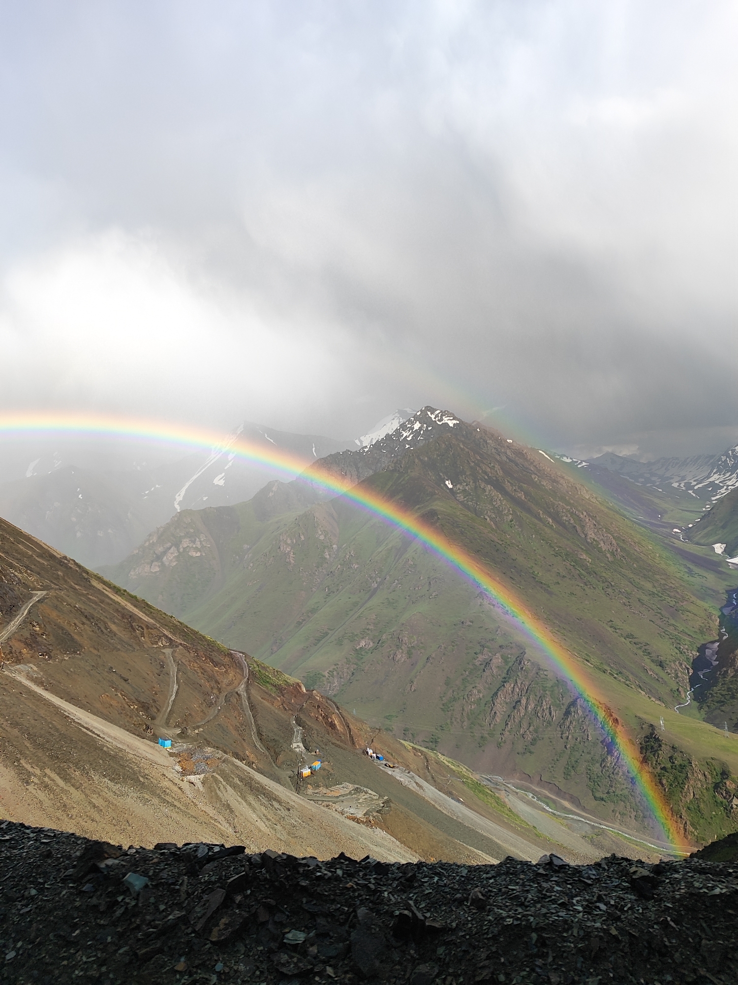 Double rainbow over a rocky Kyrgyzstan mountain valley