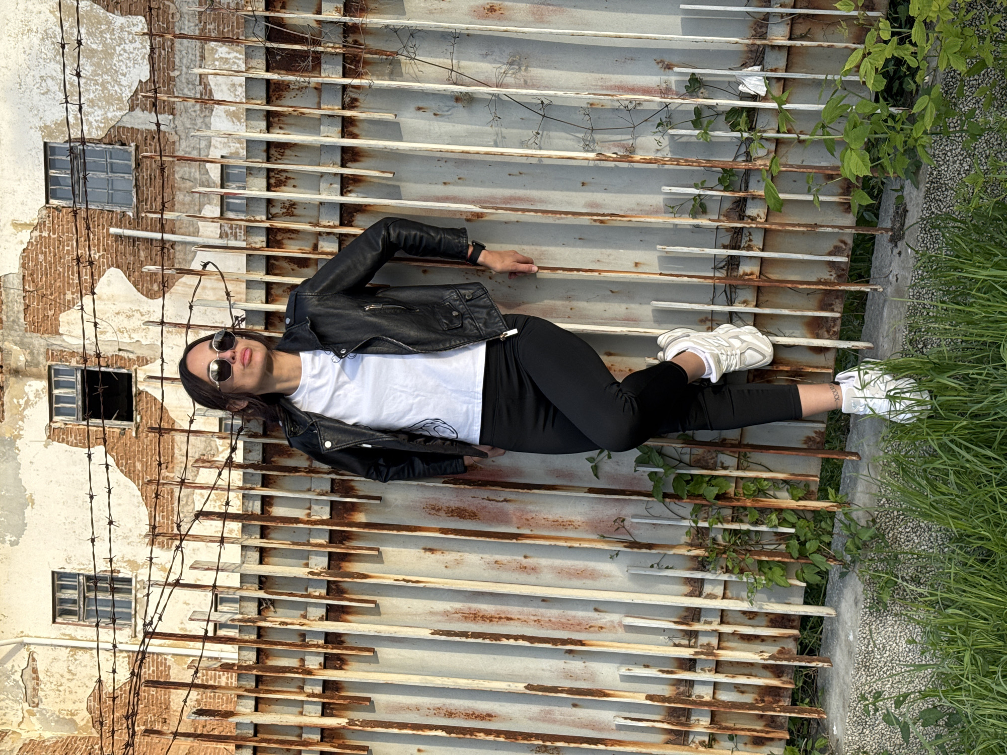 Woman poses for photos against metal fence in Pleven