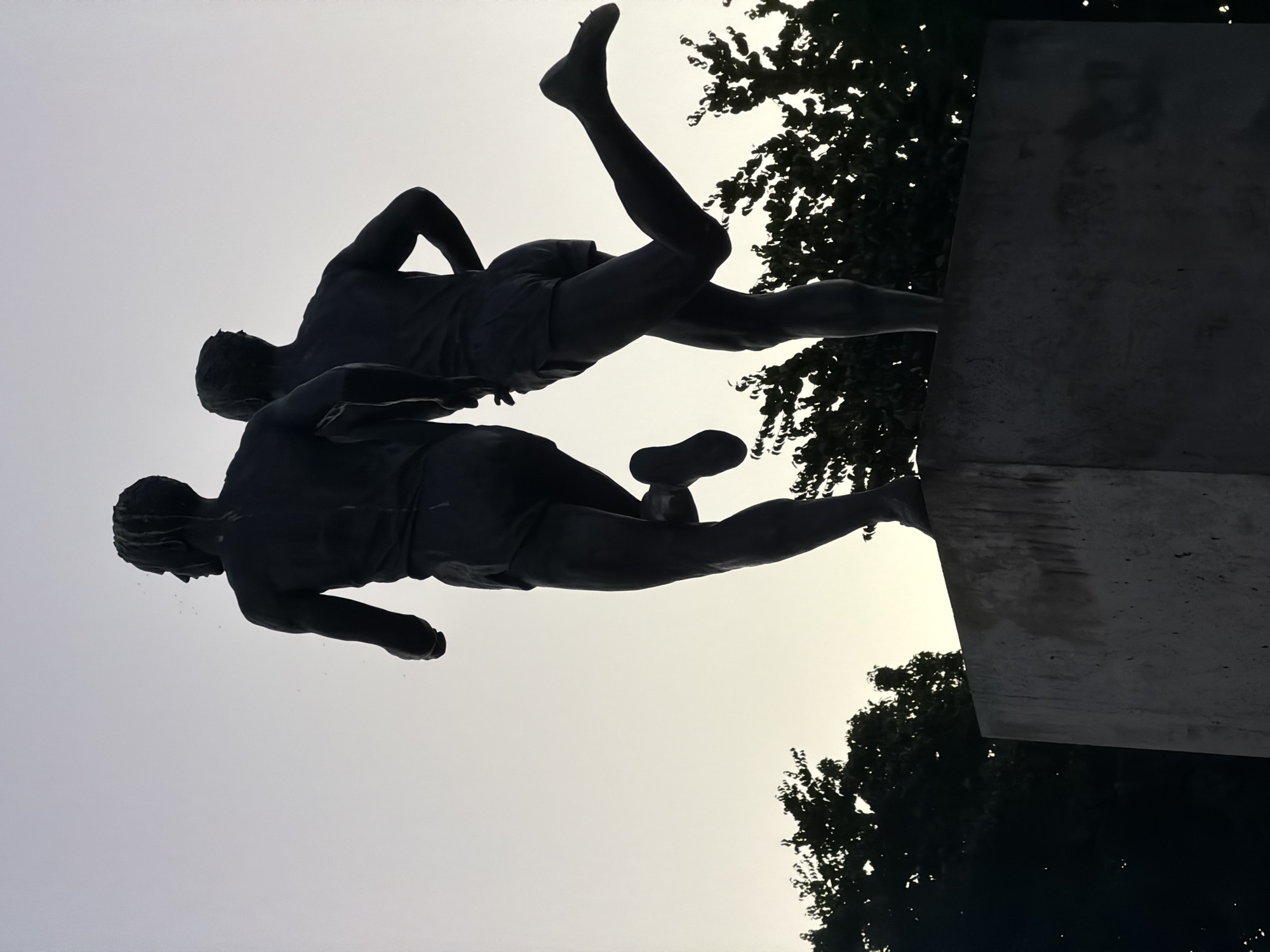 Bronze runner statues caught at dusk near a Vancouver trail