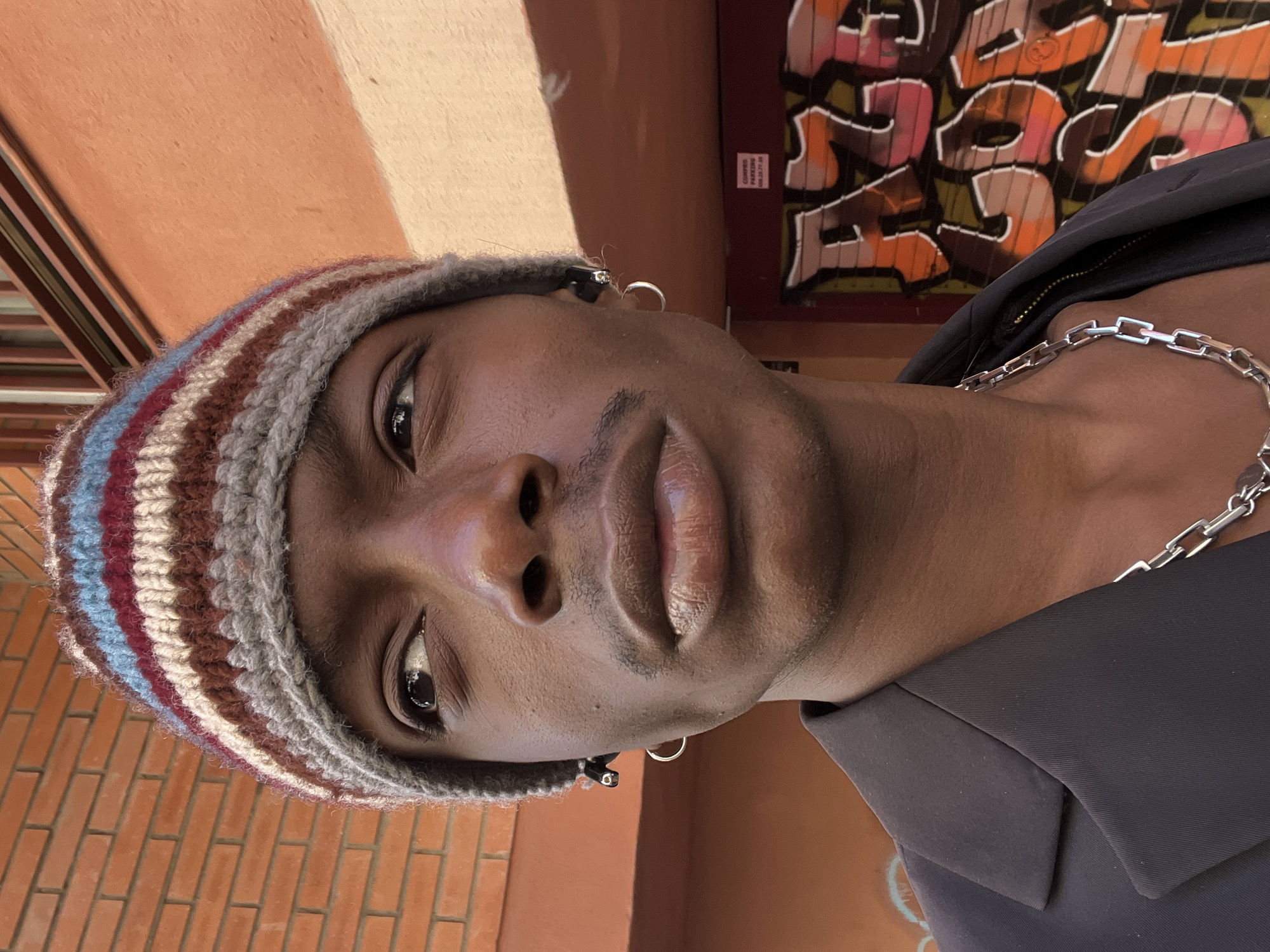 Person in striped beanie documented across Barcelona locations