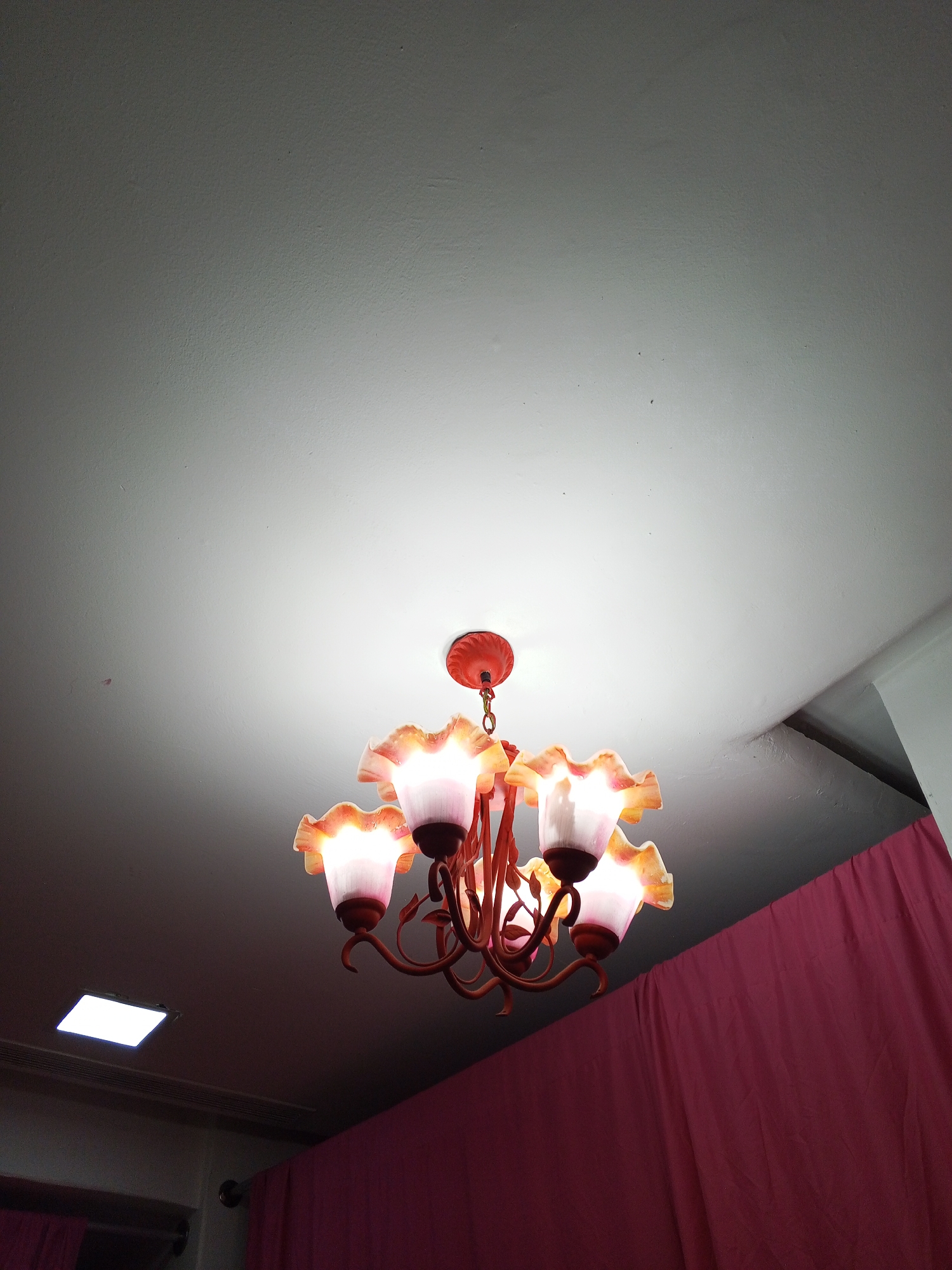 Orange flower chandelier illuminated in Porlamar interior space
