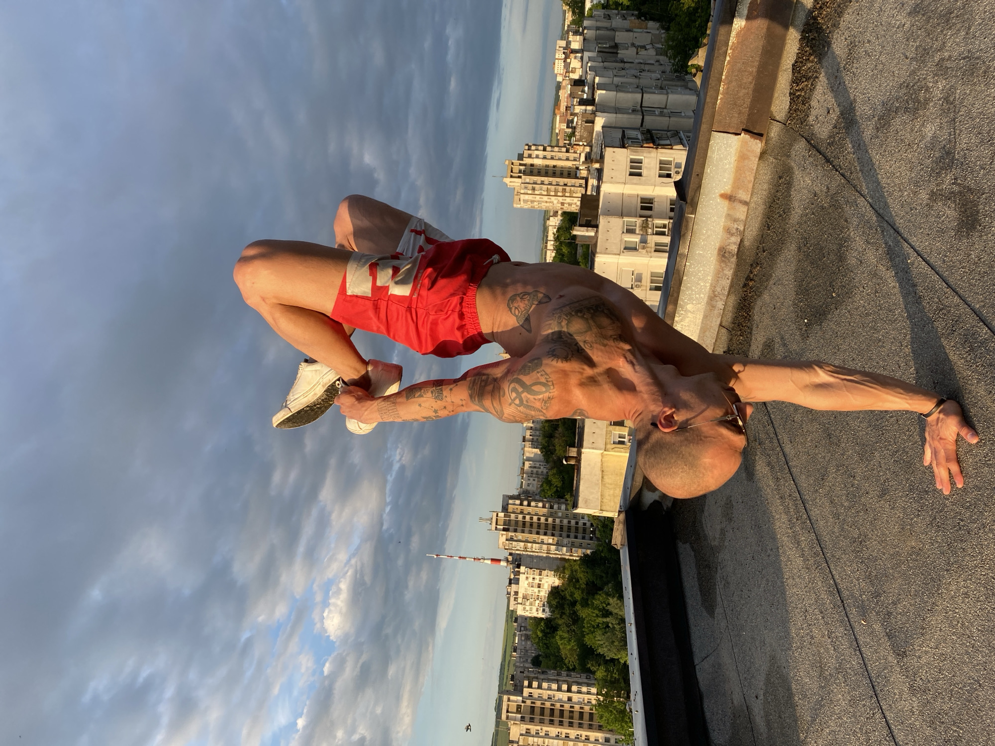 Tattooed man performs backbend on Pleven rooftop before dawn