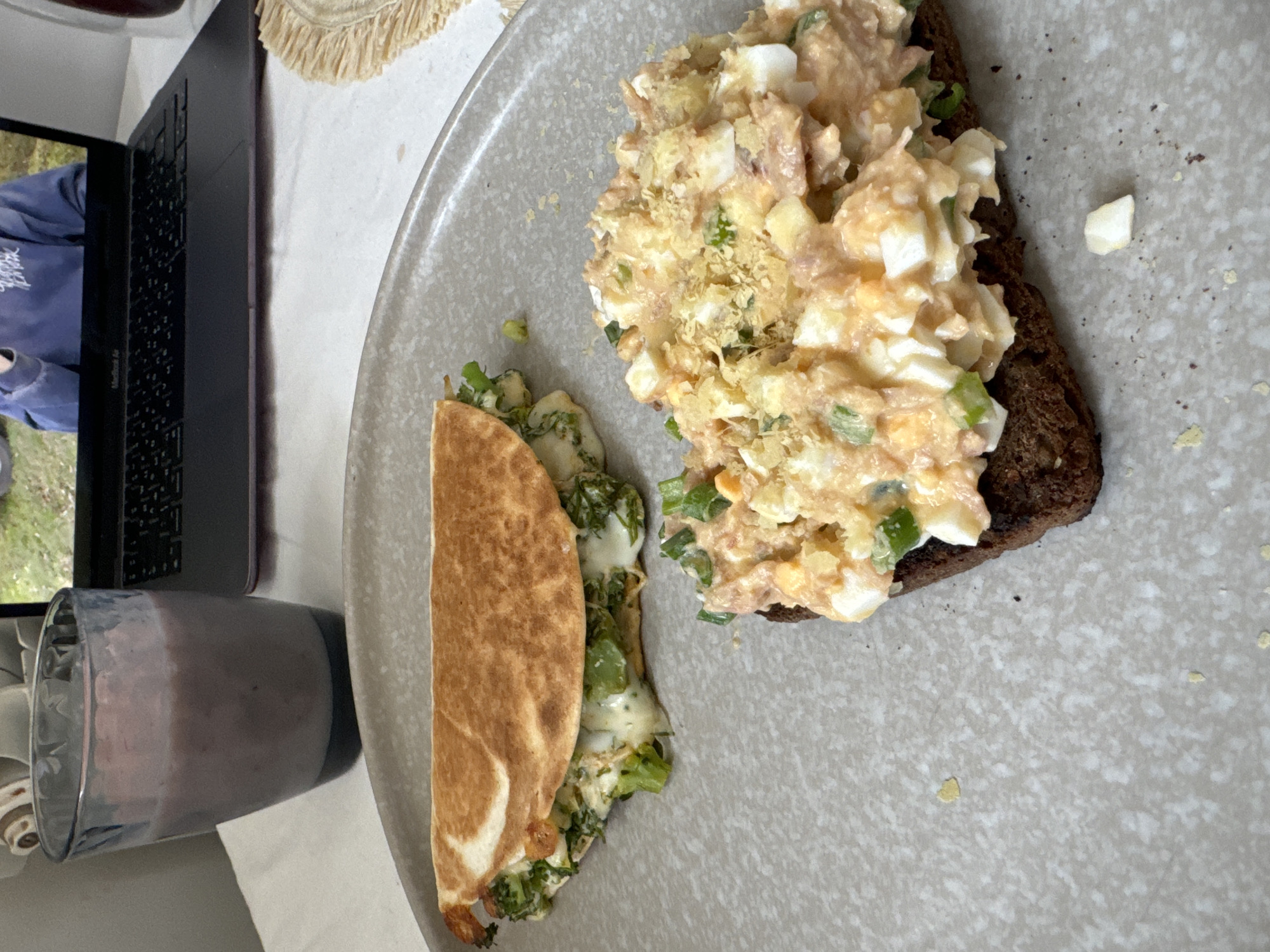 Breakfast meal photographed in Krasnoyarsk includes sandwich, quesadilla, smoothie