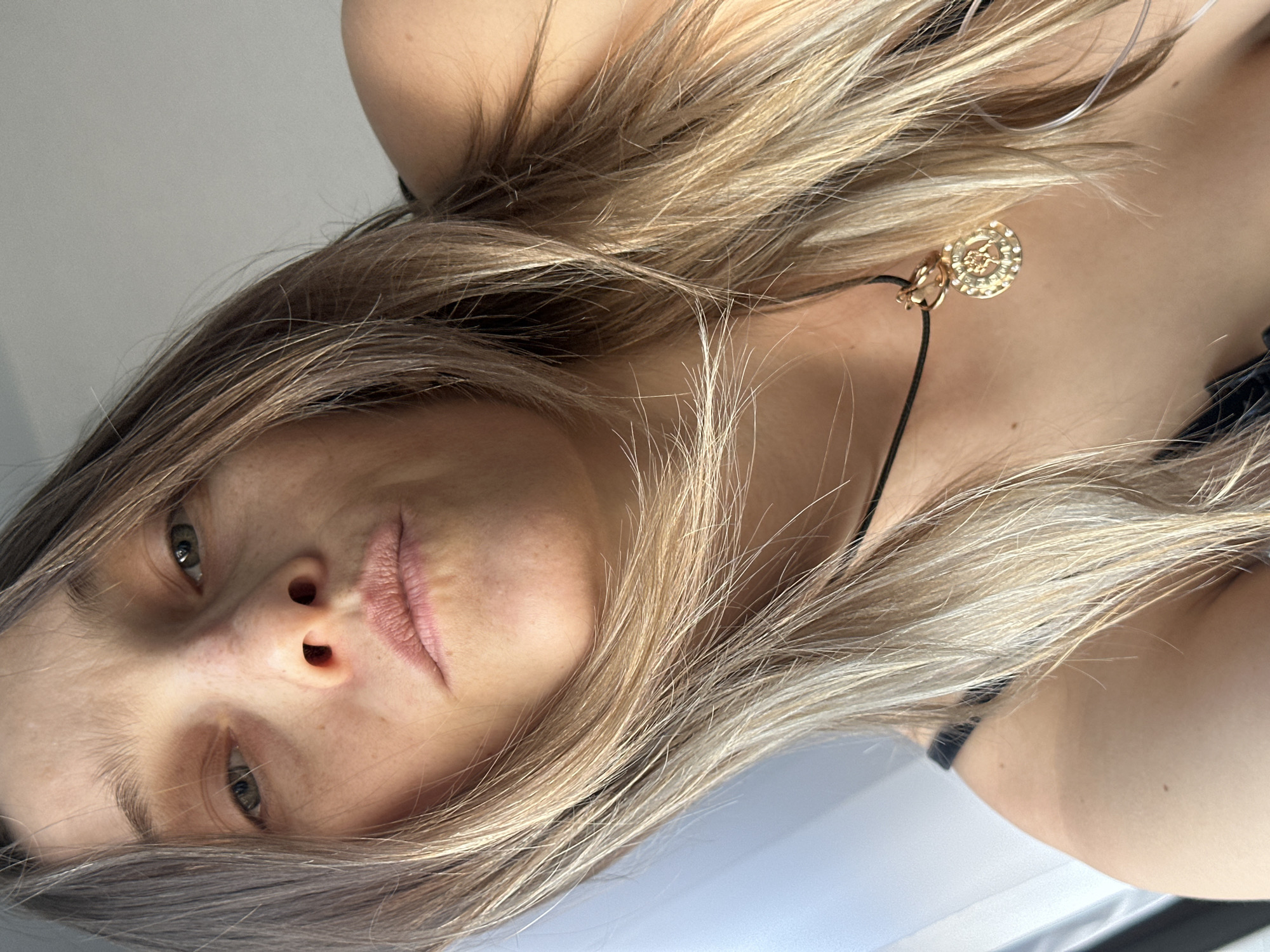 Woman photographed wearing gold pendant necklace in close-up shot