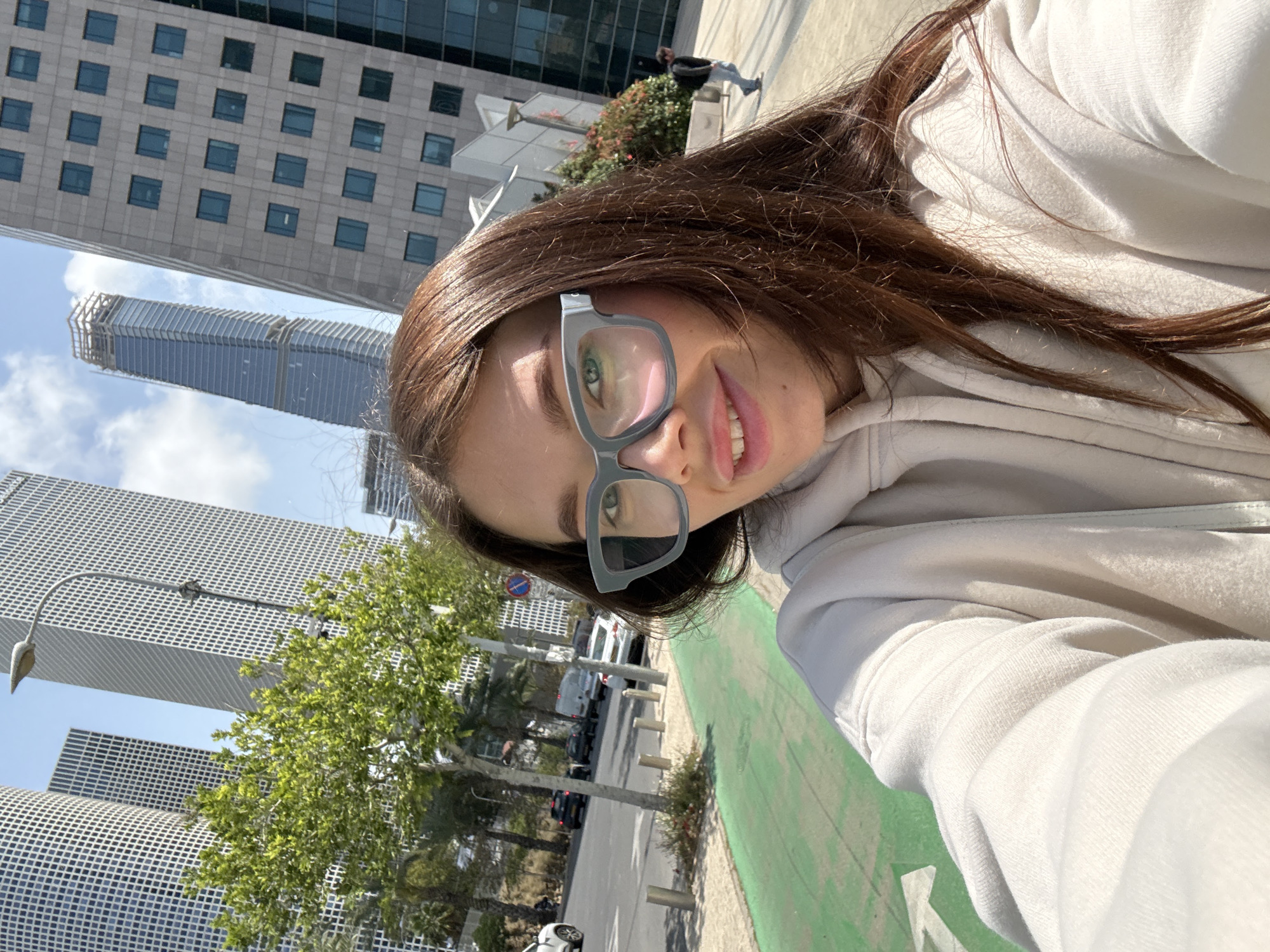Woman takes selfie in sunny Tel-Aviv street