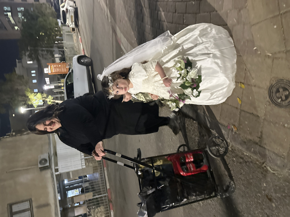 Evening street scene captures residents on Bnei Brak sidewalk