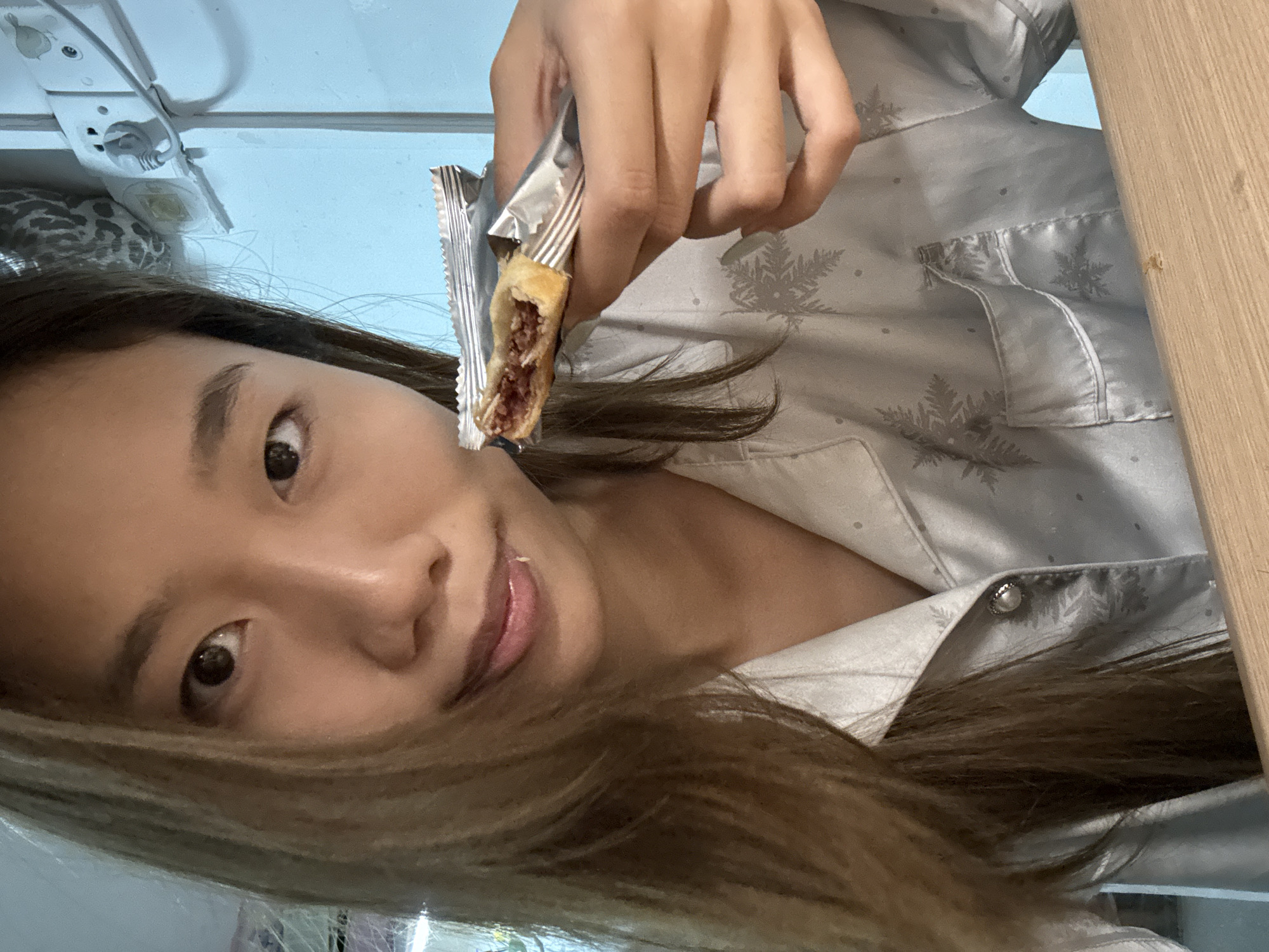 Foil-wrapped snack, pajamas, wooden table — a relaxed morning in.
