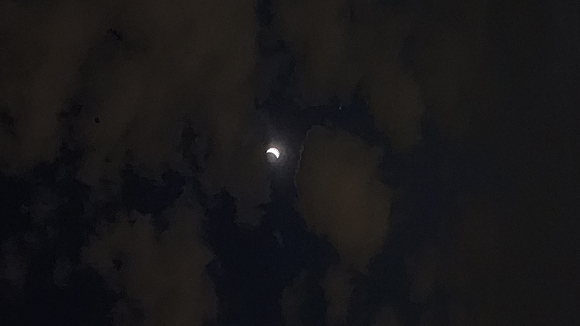 Crescent moon observed through clouds over Moscow evening sky