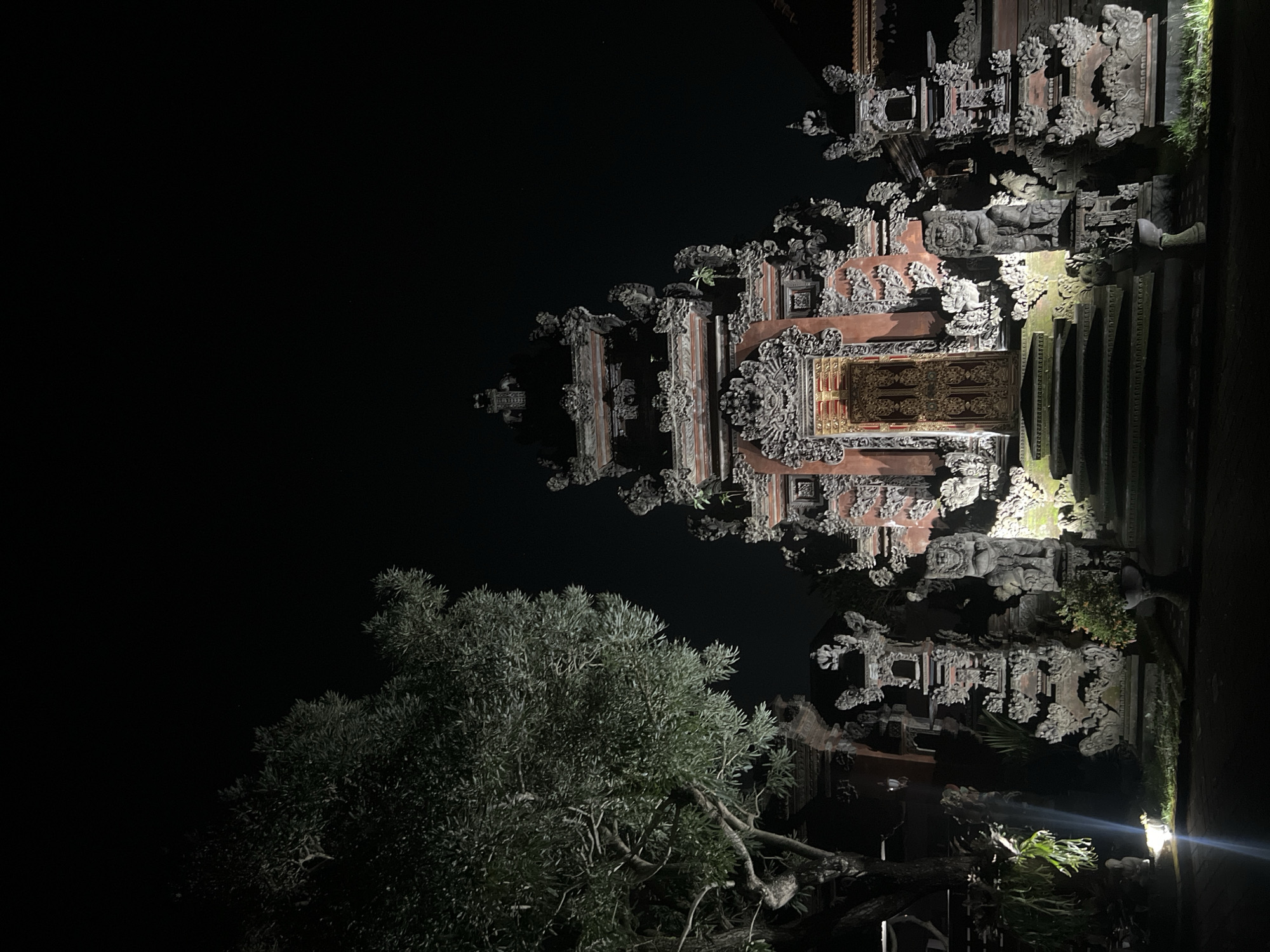 Traditional carved Balinese structure documented at night in Blahbatuh